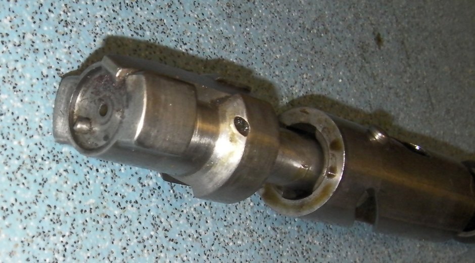 Figure 2 — The bolt head of a Chauchat, front face towards the camera: the firing-pin hole, the spring ejector standing proud of the face, and an opposed pair of lugs at the front, with the bolt body behind. …