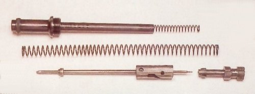 Figure 2 — The plug (bouchon) with its spring tube, the barrel recoil spring, the bolt spring, the bolt body with its firing pin, and the bolt head. Photograph: Armes Françaises (armesfrancaises.free.fr).