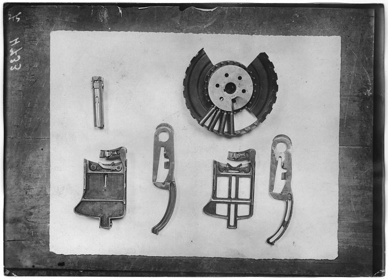 Figure 3 — Parts of an aircraft Lewis laid out in a French Army aviation workshop, September 1917: a magazine with its cover off, showing the separators, and small parts of the feed and mechanism; the individ…