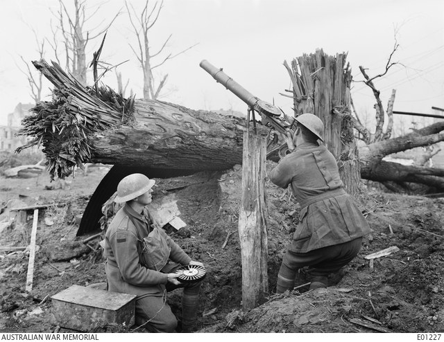 Figure 2 — Two Australian Lewis gunners of the 1st Battalion in a vantage point formed by a shell-splintered tree on the Ramparts at Ypres, 1 November 1917, during the Third Battle of Ypres, with the gun set …