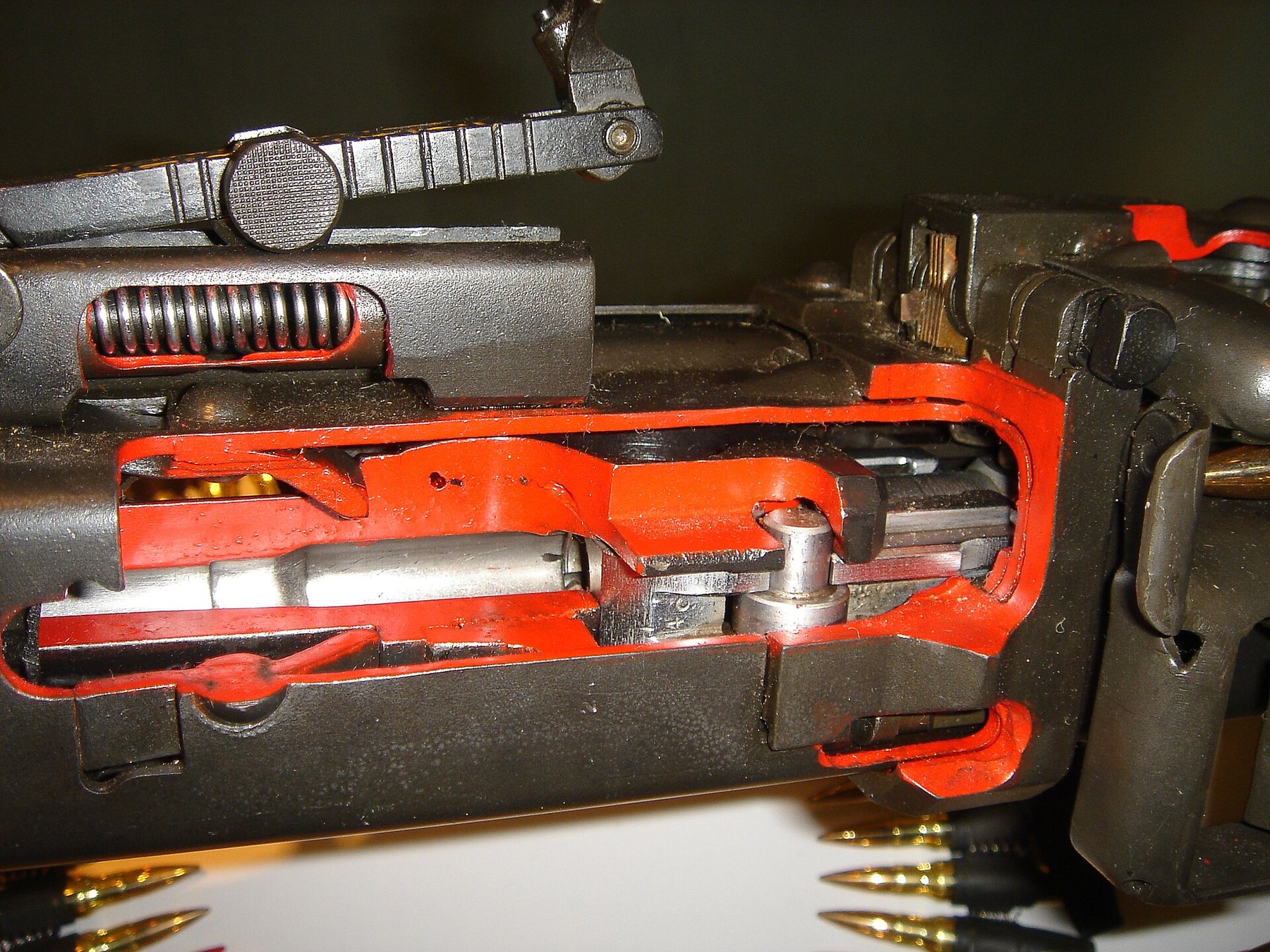 Figure 4 — A sectioned MG 42 receiver, cut edges painted red, showing the bolt head inside the barrel extension; one roller stands upright on its vertical axle at centre, the position in which it moves sidewa…