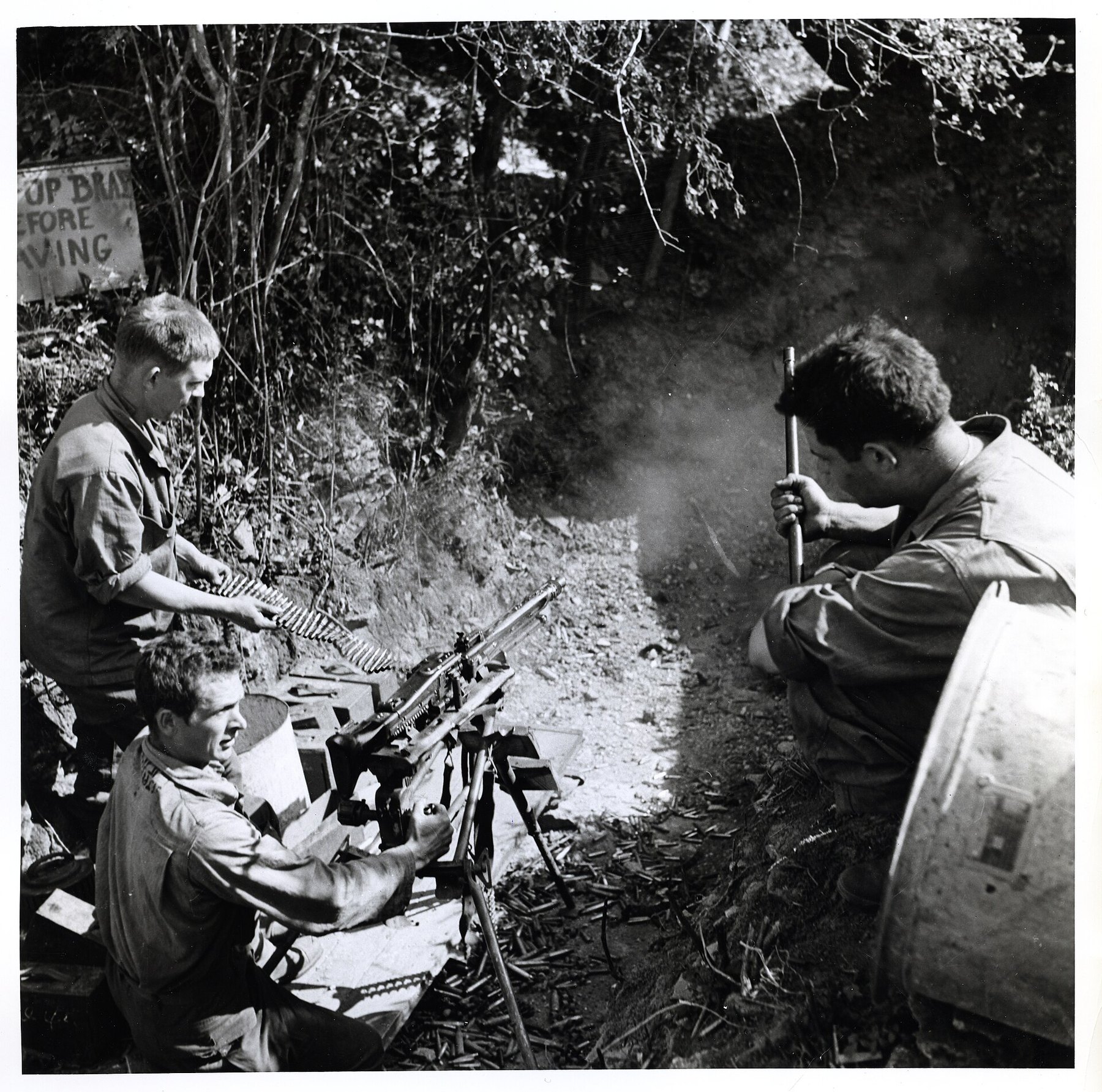 Figure 4 — US soldiers at an ordnance depot in Normandy test-firing a captured MG 42 in a pit in 1944; the Signal Corps caption says the loader "feeds ammunition into the gun, which uses it up at the rate of …