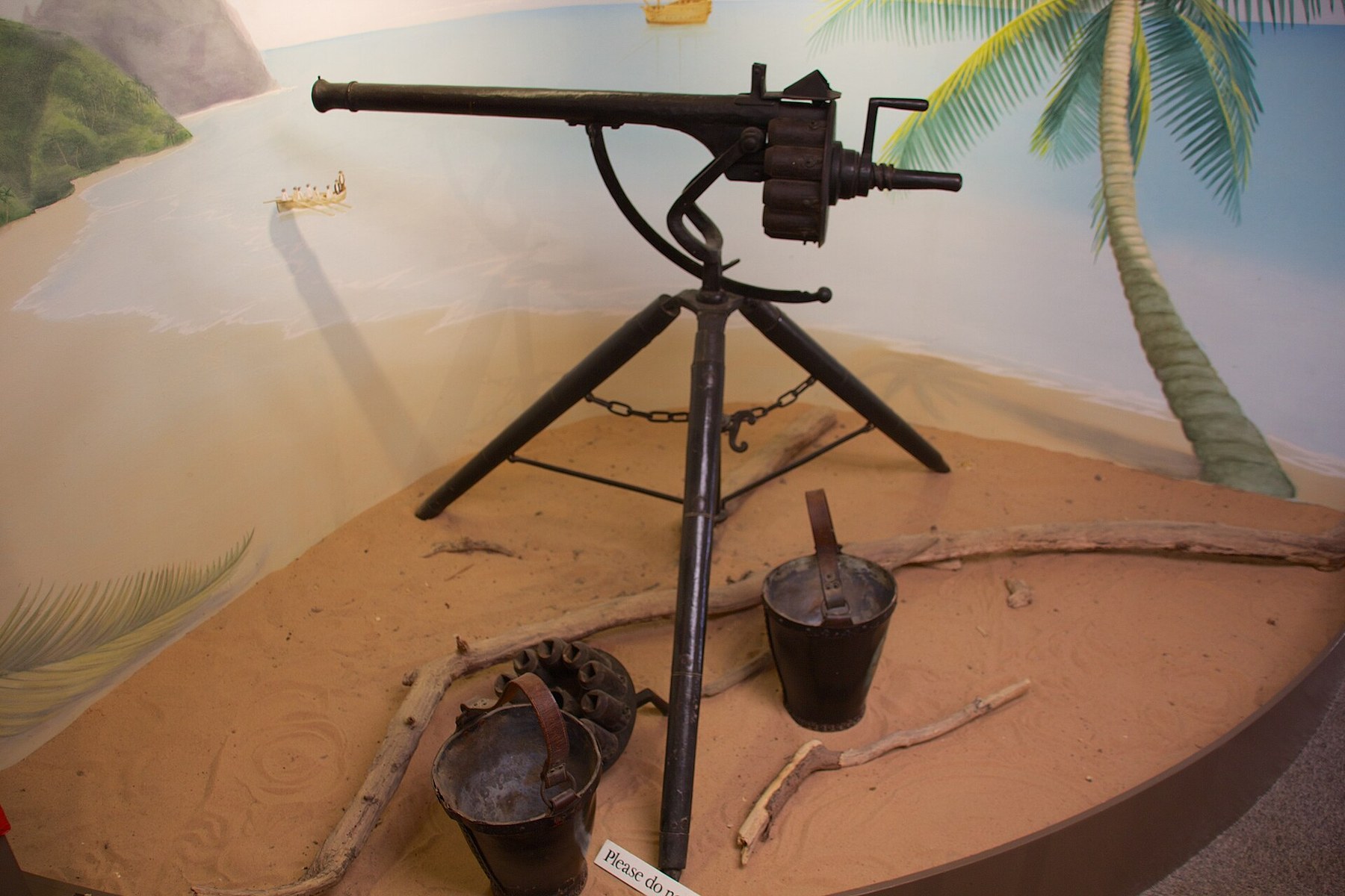Figure 4 — The iron Puckle-pattern gun at Buckler's Hard Maritime Museum, Beaulieu, in its beach diorama (muzzle left). The lock stands on the breech above the chamber set; a crank projects behind; a spare ch…