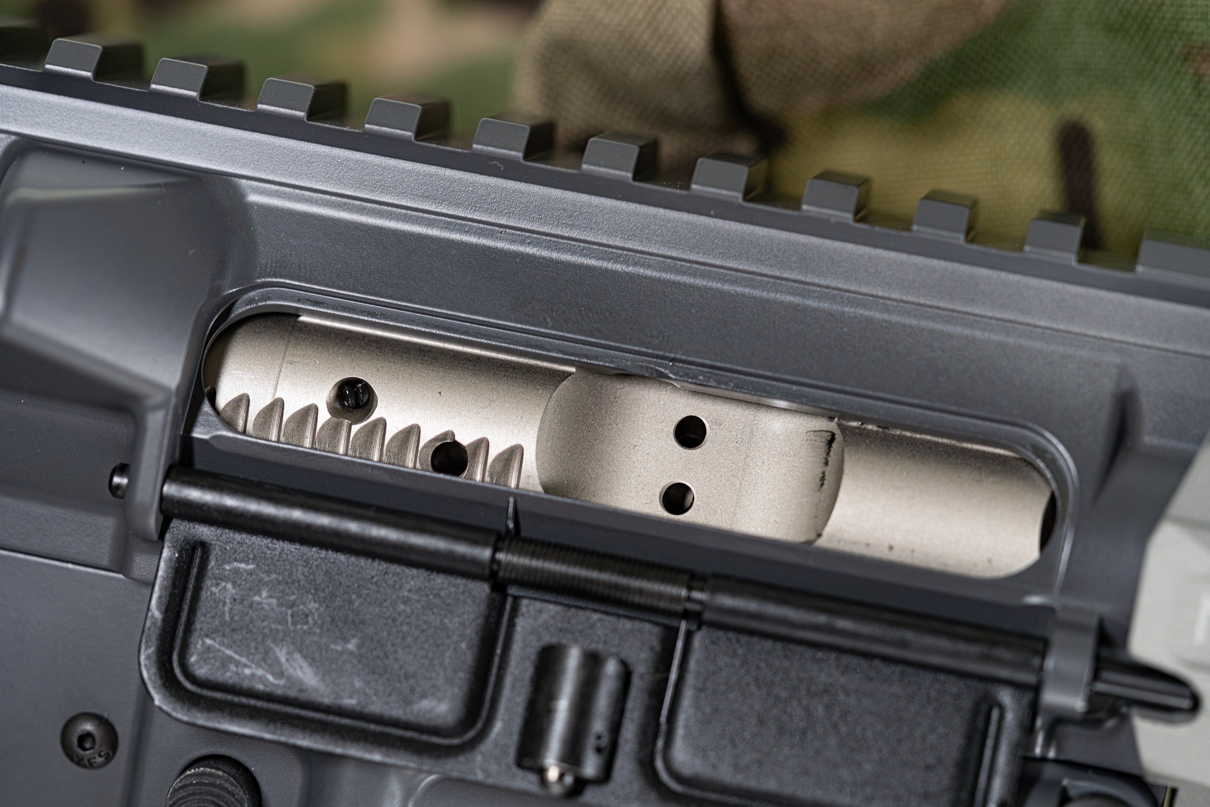 Figure 7 — The bolt carrier group visible through the ejection port. On a .300 Blackout build this is the same bolt and the same carrier as a 5.56 rifle — the case head dimensions are identical, which is exac…