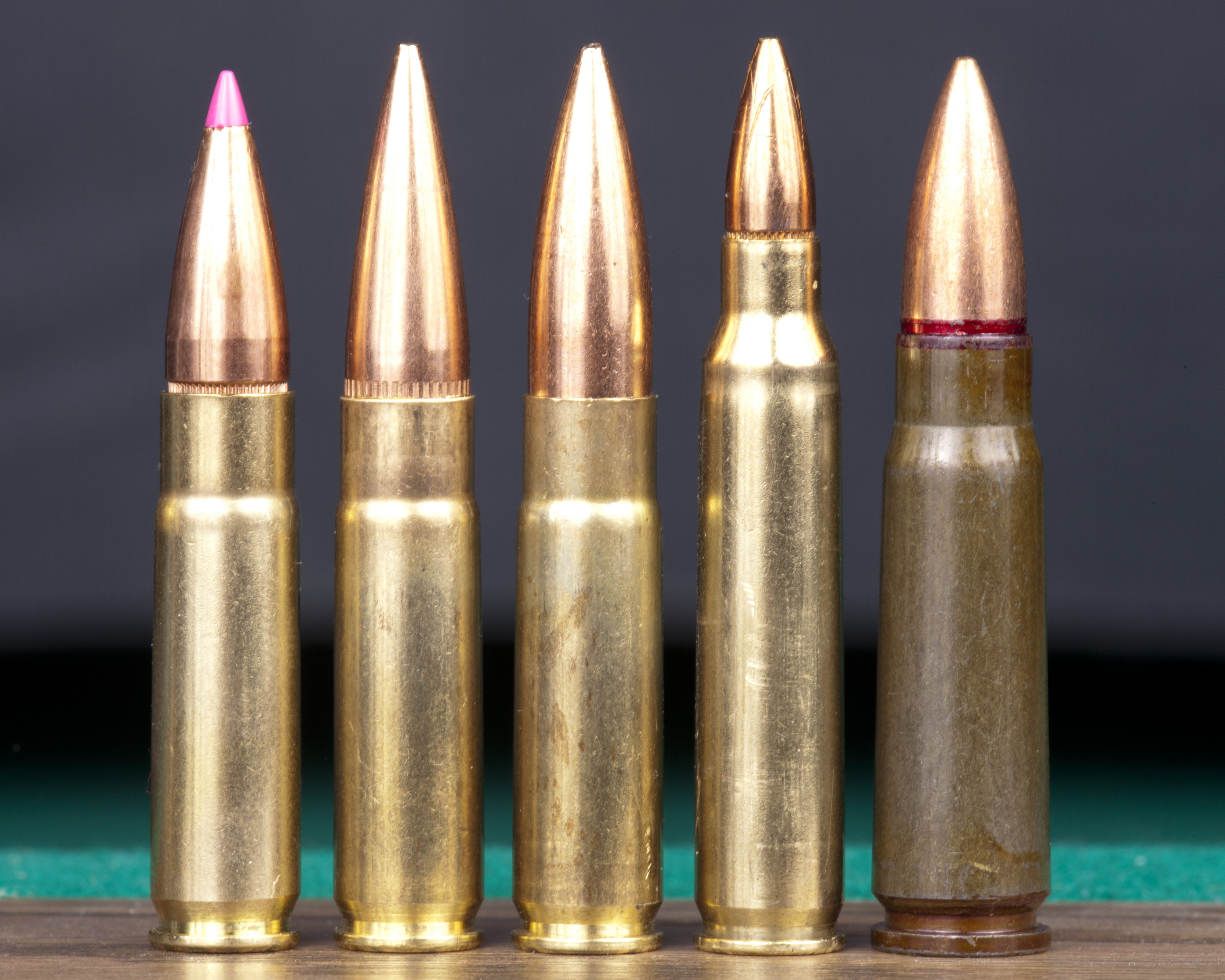 Figure 1 — Five cartridges of the family photographed together. The span between the lightest supersonic load and the heaviest subsonic one is the largest of any common cartridge, and it is the source of almo…