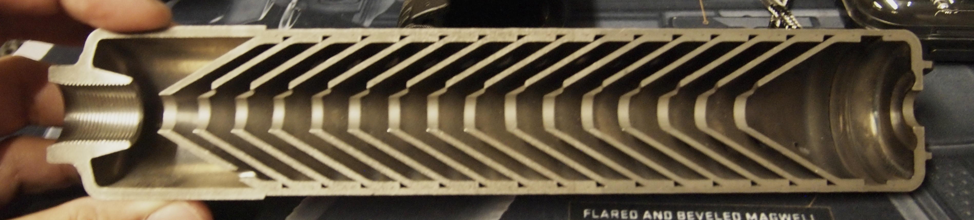Figure 5 — A sectioned suppressor showing the baffle stack. The first baffle — the blast baffle at the left — is the part an 8-inch barrel punishes, and it is the part the rating in §5.3 is about. Source: com…