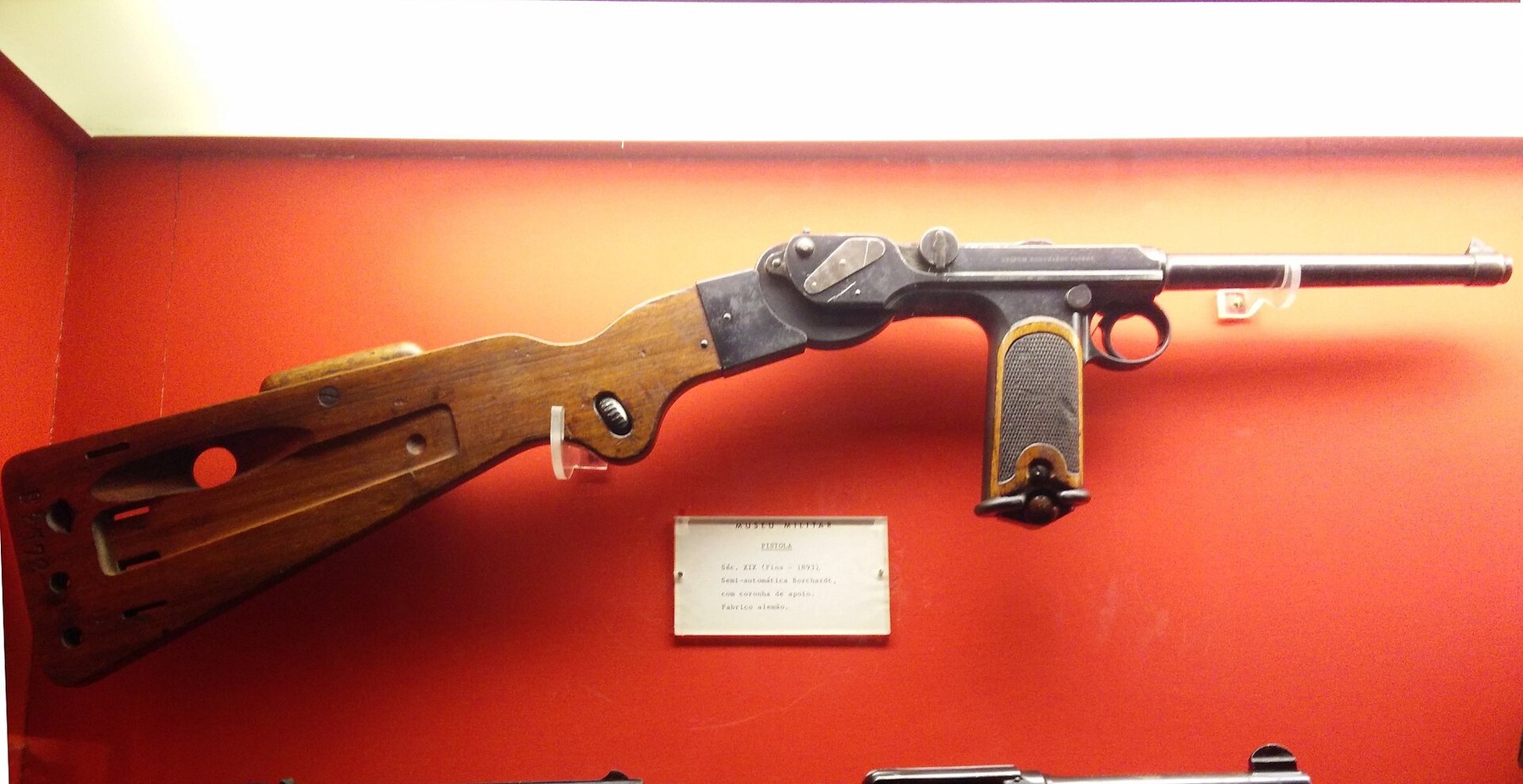 Figure 9 — A C-93 with its board stock attached, in a museum case. The stock clamps to the tenon on the back of the spring box; the leather holster that laces to the stock is not fitted in this display.