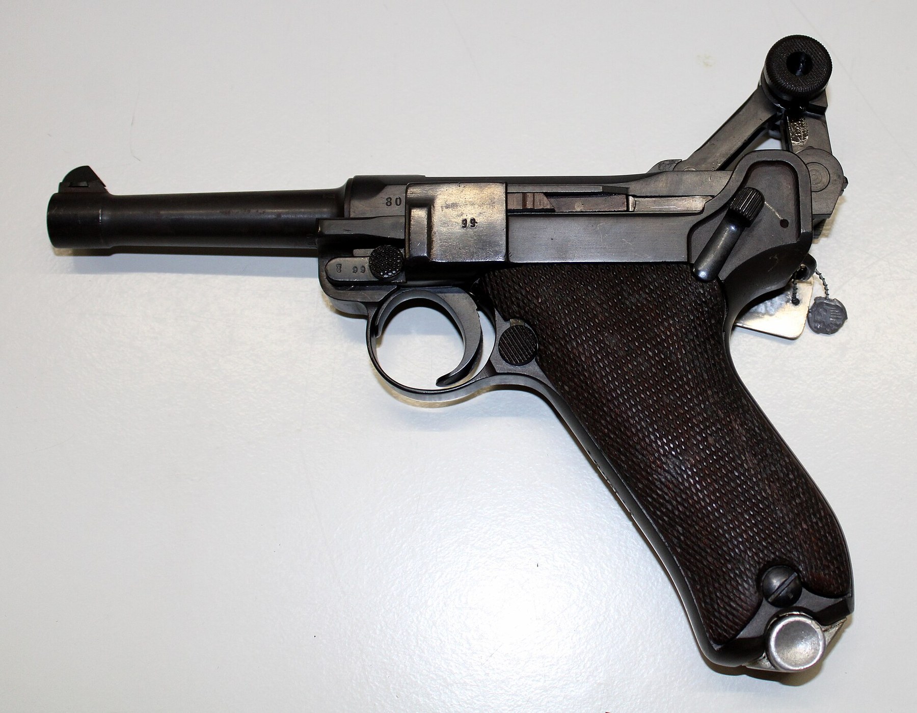 Figure 10 — The same Pistole 08 with the toggle broken upward and held open. The knee rises exactly as the C-93's does; what is different is what lifts it and where the spring lives.