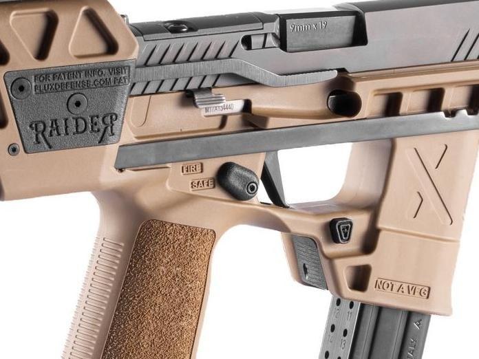 Figure 3 — The Raider X in FDE, right side, close up, from Flux's product photographs. The chassis safety lever sits above the trigger with FIRE and SAFE moulded beside it; the dual magazine release button is…