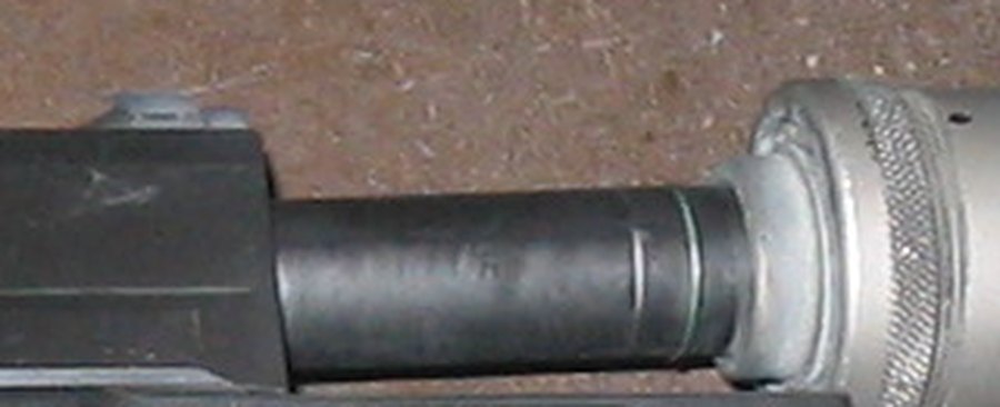 Figure 3 — The Mark 23's muzzle with a suppressor fitted, enlarged: the barrel visible between the slide and the suppressor's mount. The threads themselves are hidden under the mount.