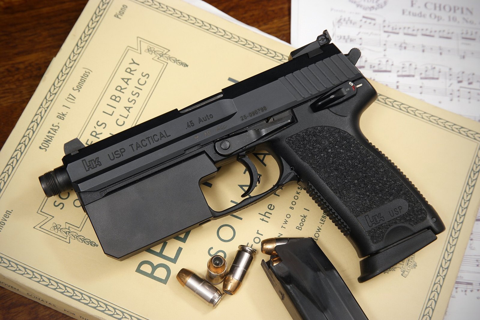 Figure 3 — A USP Tactical in .45, its slide marked "USP TACTICAL" and ".45 Auto". The threaded barrel protrudes beyond the slide; the frame carries the USP's single control lever at the rear.