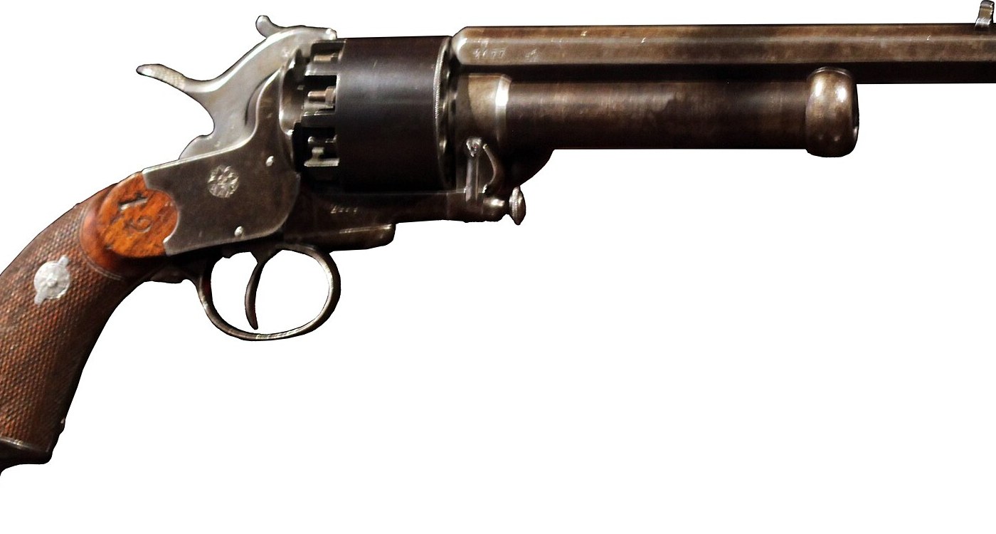 Figure 3 — A Paris LeMat in the Musée de l'Armée, right side, close. The cylinder turns on the shot barrel; the knurled head of the barrel assembly pin is on the frame below the cylinder's front; the trigger …
