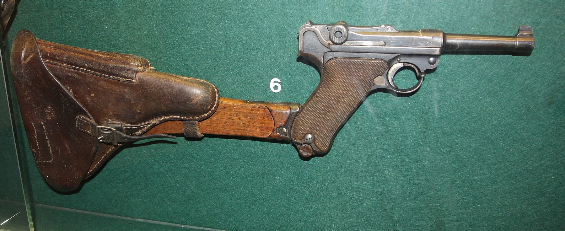 Figure 6 — A Finnish m/23 in 7.65 mm with its holster-stock, in the Mikkeli Infantry Museum. The stock is a wooden board with a leather holster attached, the arrangement the long pistol's stock also used. Pho…
