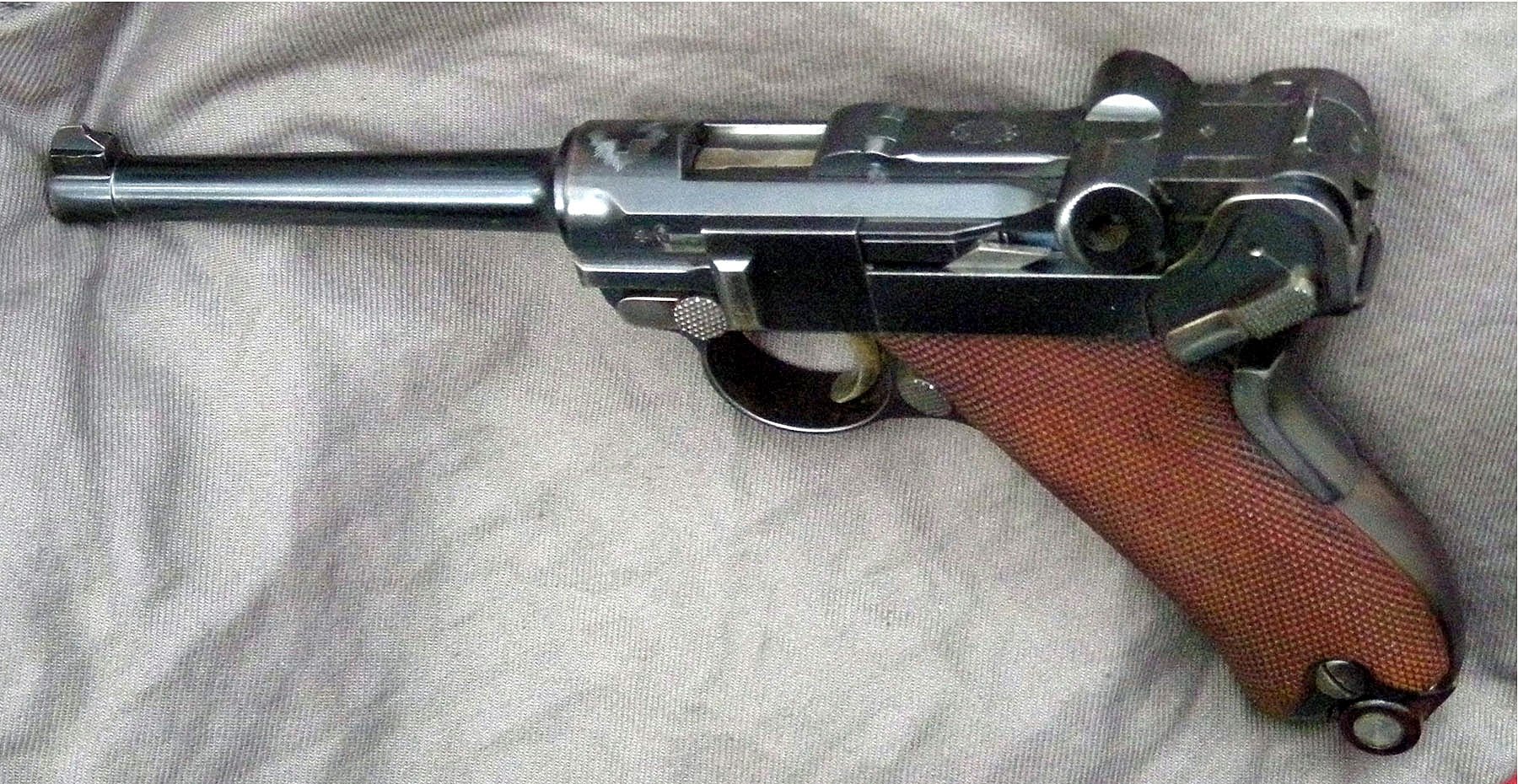 Figure 4 — A Swiss Pistole 1900, photographed by the same collector as the first figure in this volume, with the toggle partly raised. The photographer identifies it by the Swiss cross "in splendour" over the…