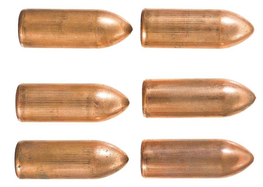 Figure 6 — Six round-nose 13 mm rockets in profile, with the ogive nose and plain cylindrical case of the standard production round. Rock Island Auction Company photograph, used by owner decision.