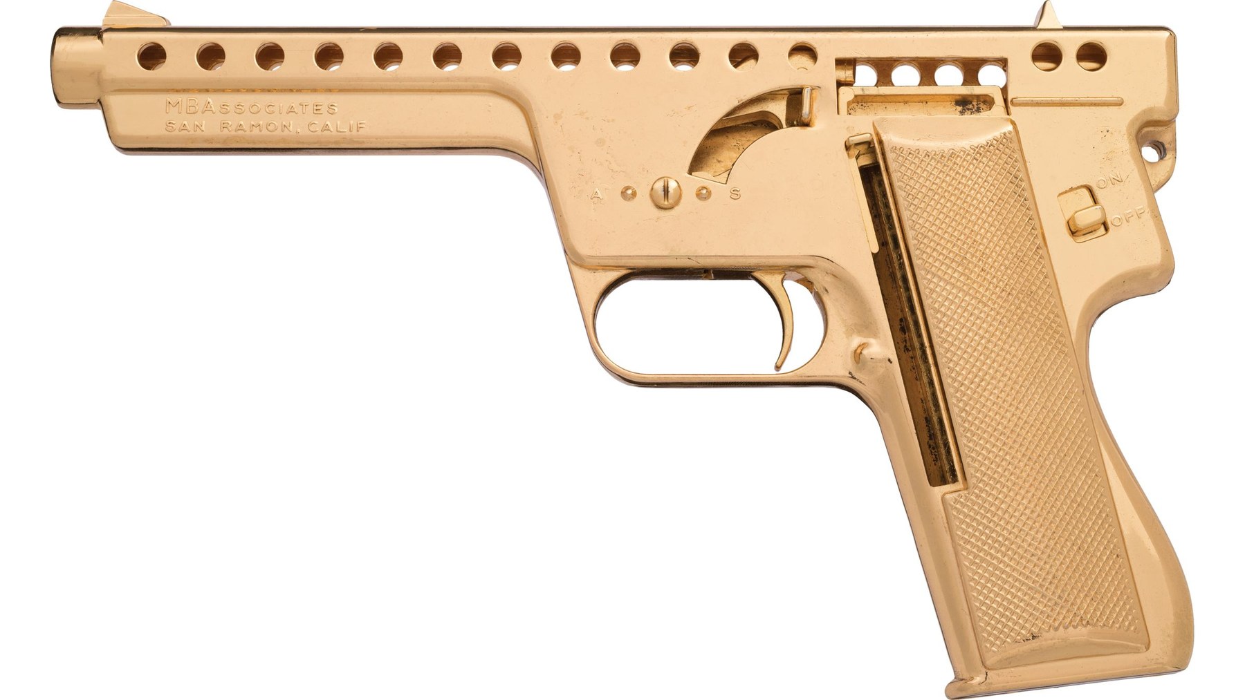 Figure 4 — A gold-plated Model 137, left side: the cast-in checkered grip, the MBAssociates San Ramon address on the lug, and the plugged selector marked A and S below the hammer slot. Rock Island Auction sol…