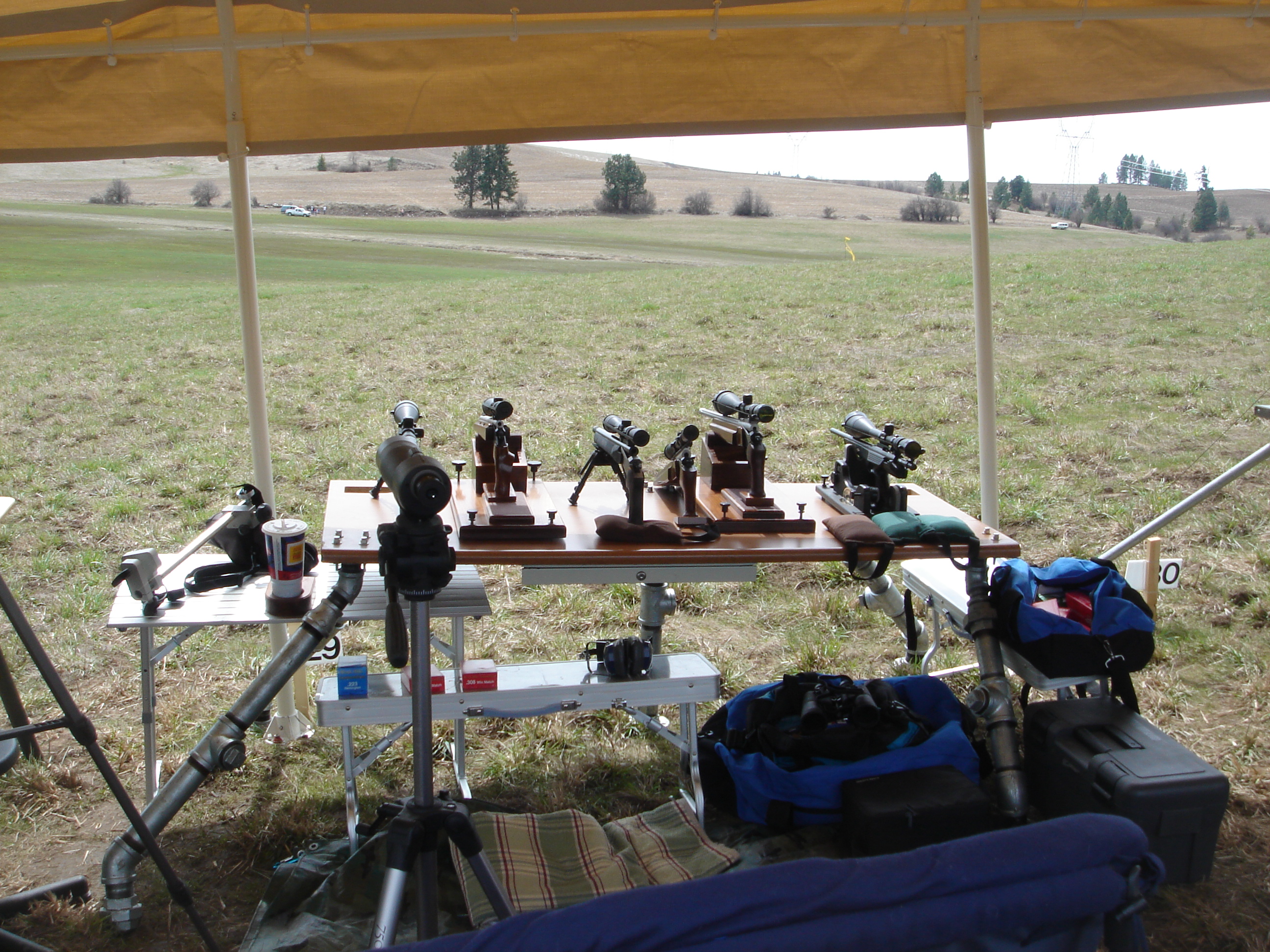 Figure 2 — Silhouette pistols racked on a bench at a shooting event. The configuration the game produced — long barrels, heavy stocks, big scopes — is what Remington was chasing when it introduced the 14½-inc…