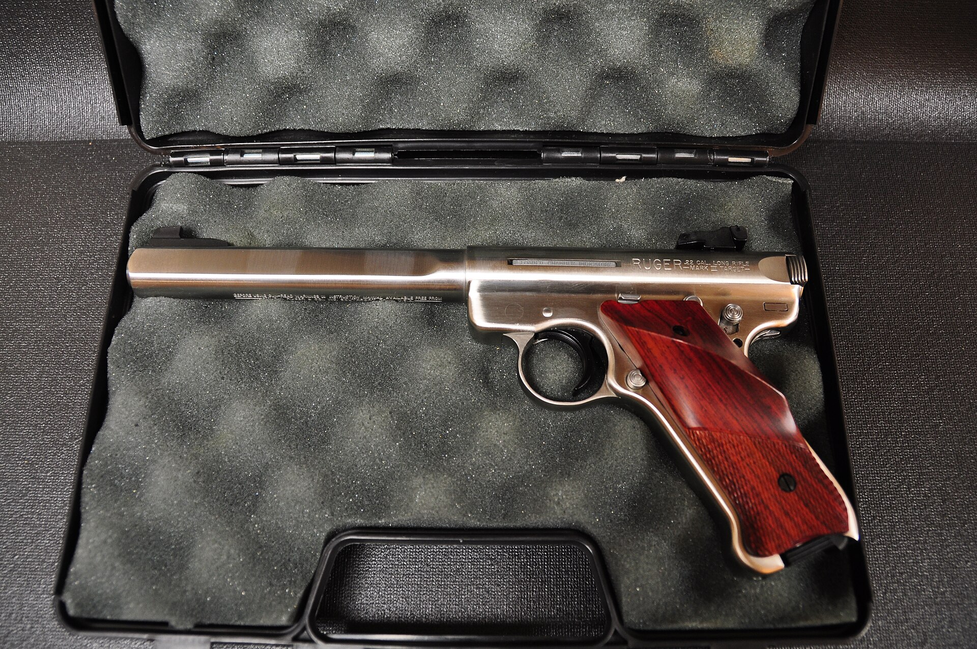 Figure 9 — A stainless Mark III Competition, with the slab-sided heavy barrel and target grips Ruger's manual describes for that model. The loaded-chamber indicator legend and the MARK III TARGET roll mark ar…