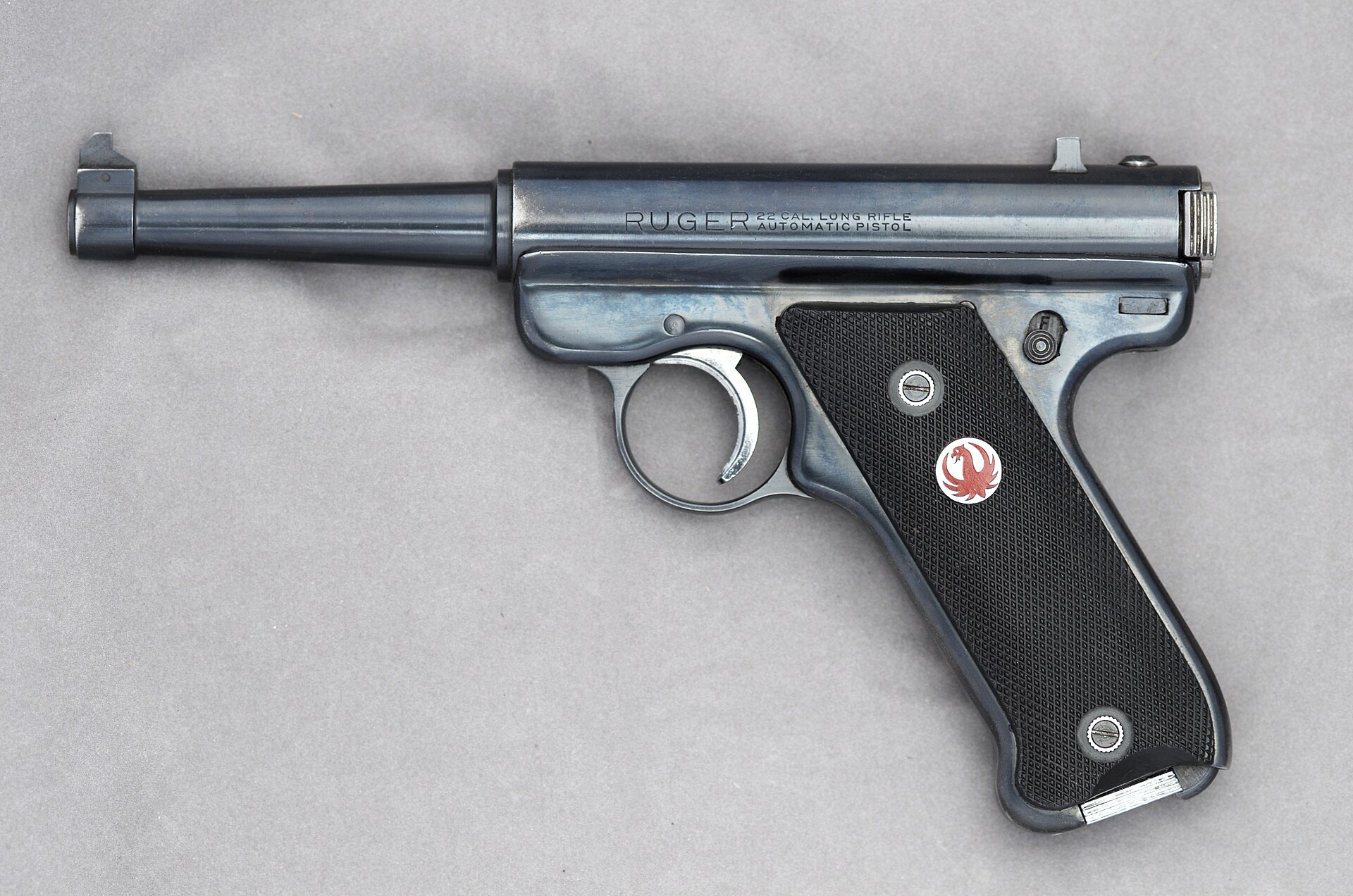 Figure 1 — A Ruger Standard, serial number 41, left side: the tapered 4¾-inch barrel, the round receiver tube with no slide, the heel magazine catch at the bottom of the grip, and the red-centred bird medalli…