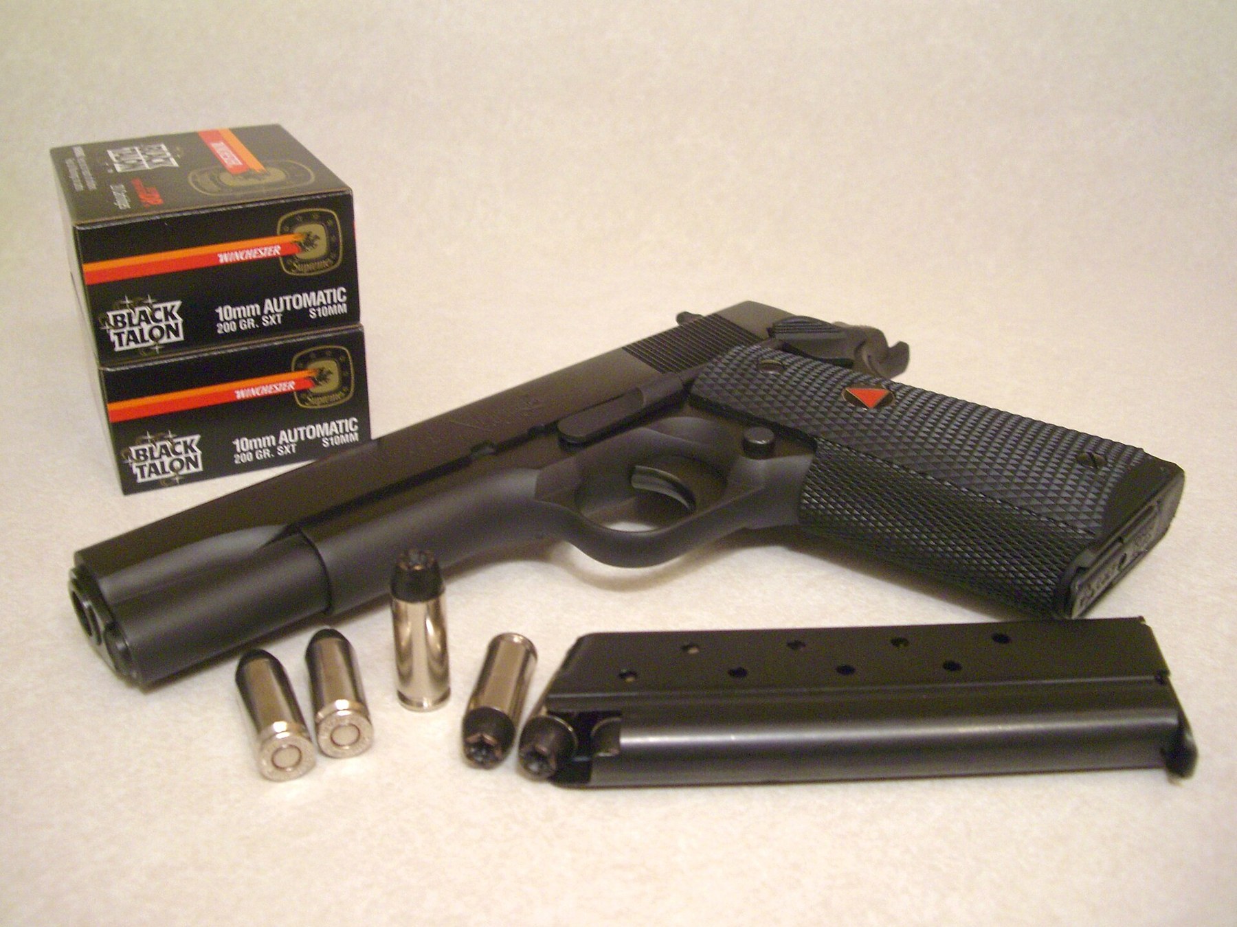Figure 5 — A Colt Delta Elite, the 1911-pattern pistol chambered in 10 mm Auto, with 10 mm cartridges. Full-power 10 mm is a substantially more powerful round than the load the FBI eventually settled on, and …