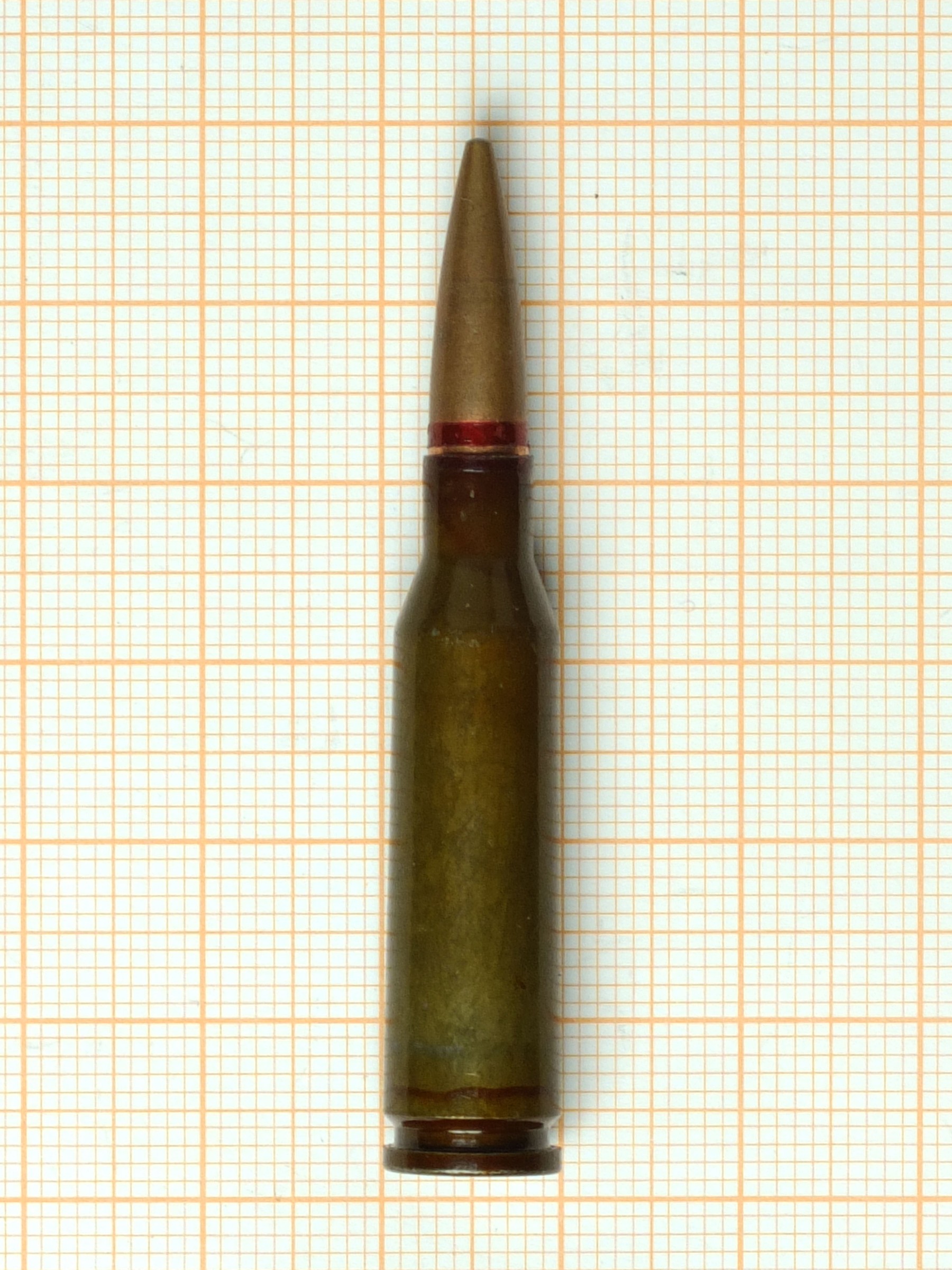 Figure 2 — A single 5.45×39, photographed on the same graph paper as the 7.62×39 in Volume 3. The difference in bulk is the difference in how many a soldier carries.