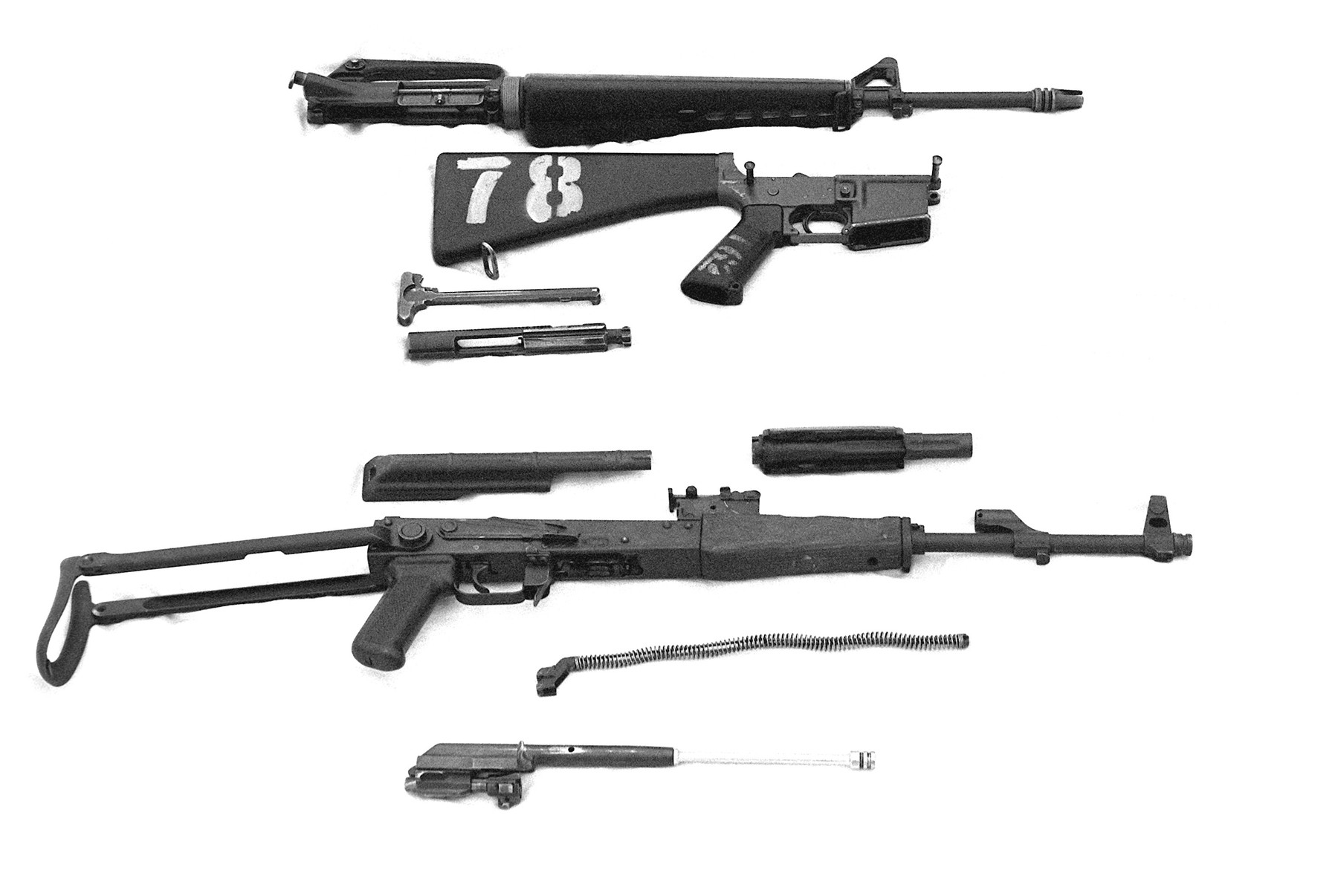 Figure 3 — An AK and an M16 stripped side by side in a US Department of Defense photograph. The AK's parts count is lower and every part is larger; neither of those facts settles the reliability argument on i…