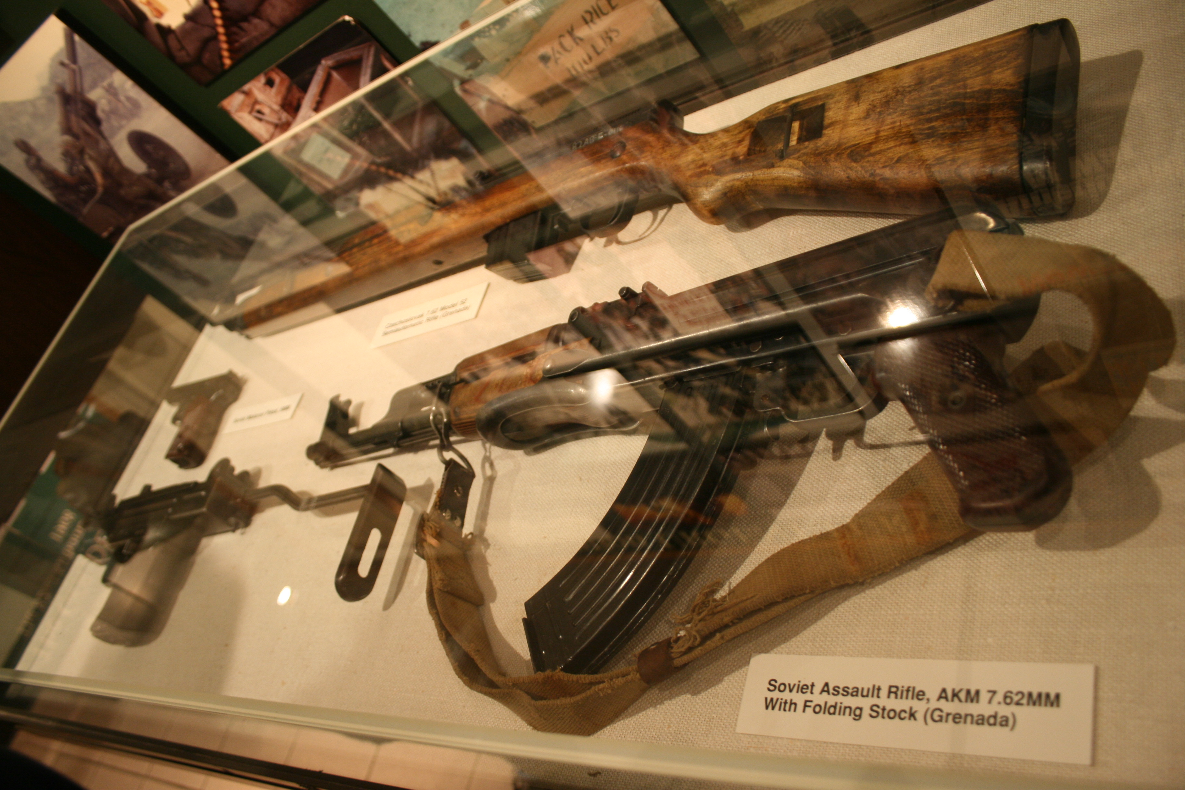 Figure 3 — An AKM with the underfolding stock, displayed with its museum placard identifying it as Soviet and captured in Grenada. Provenance of this kind is worth more than any feature reading.