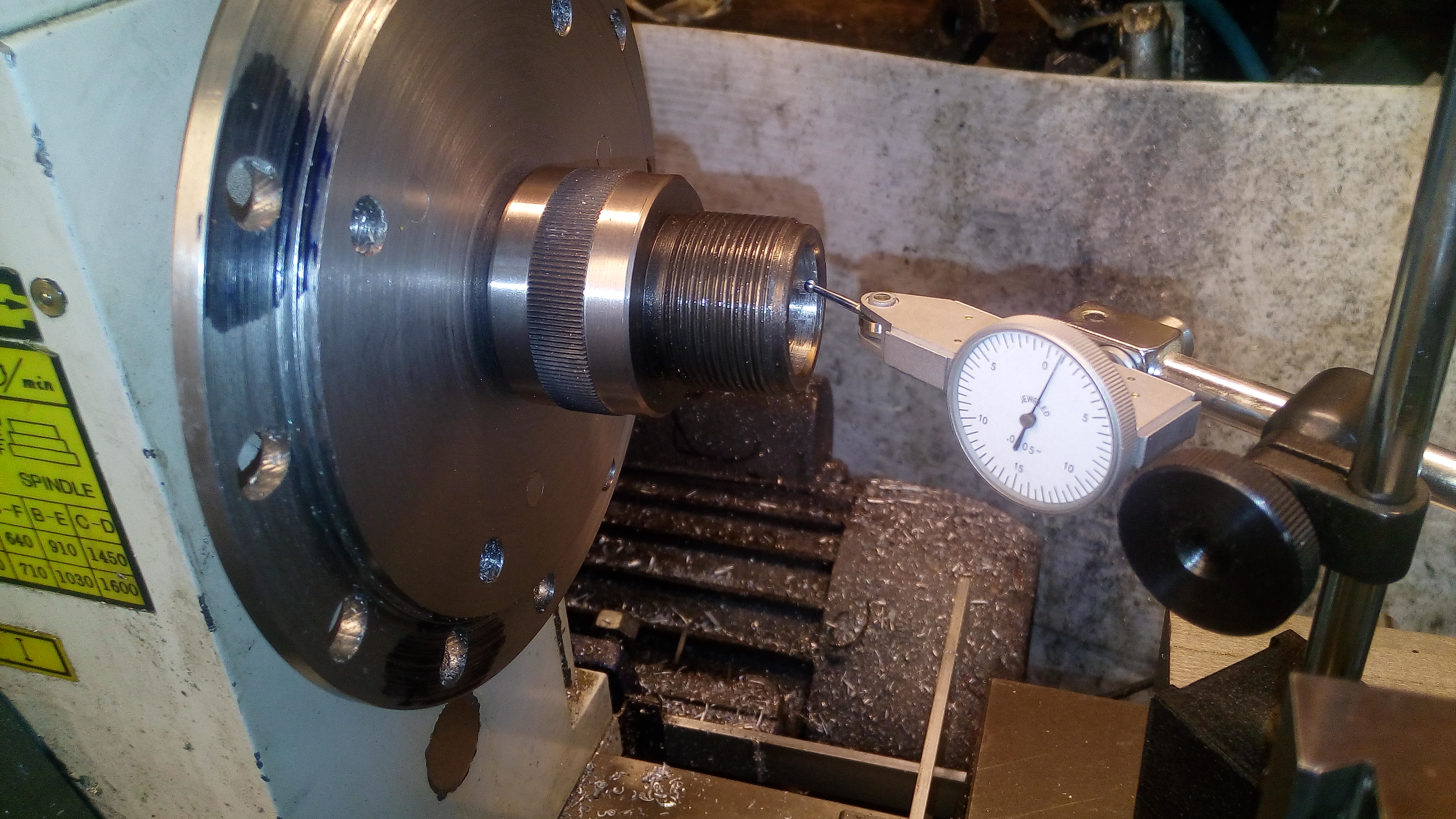 Figure 3 — A dial test indicator being used to set work true. The equivalent step on this build is sweeping the barrel to confirm its axis lies parallel with the mill's X travel before the spot drill touches …