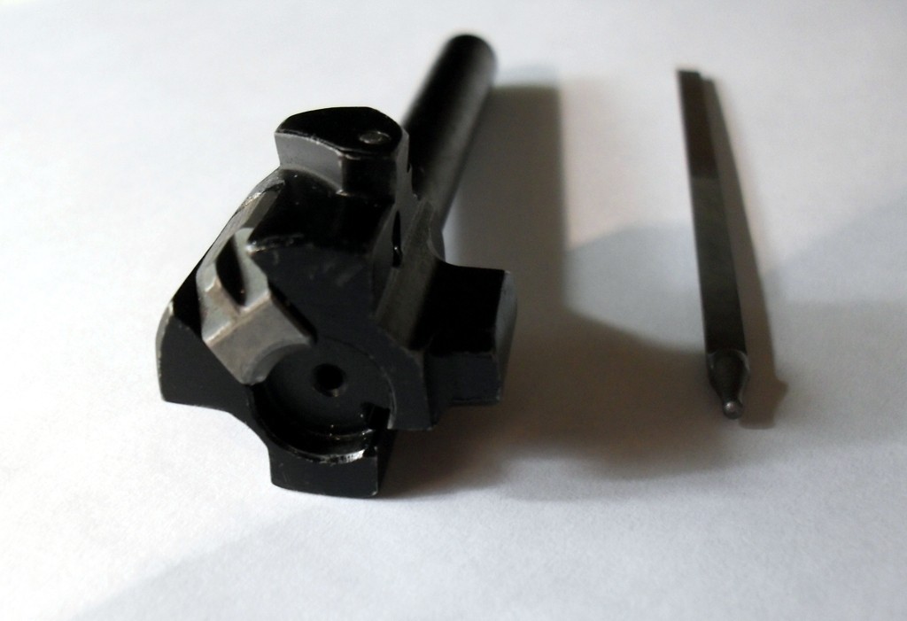 Figure 4 — An AK-pattern bolt with its striker. Two lugs, a cam pin, and nothing else — there is no gas key, no separate locking piece, and no adjustment anywhere in the assembly.