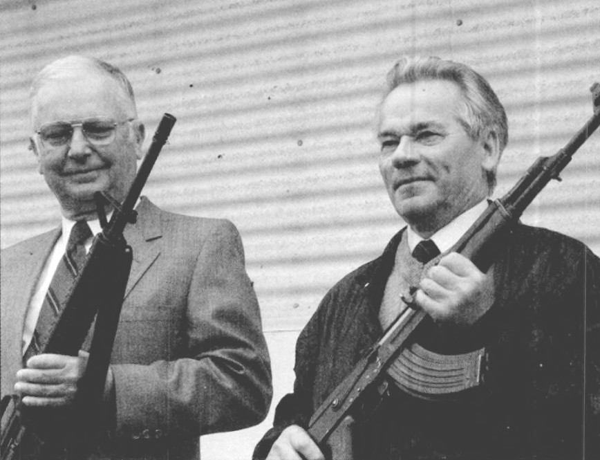 Figure 6 — Eugene Stoner and Mikhail Kalashnikov holding each other's rifles. The two designs are argued about endlessly and were built to different requirements, in different industries, for different armies.
