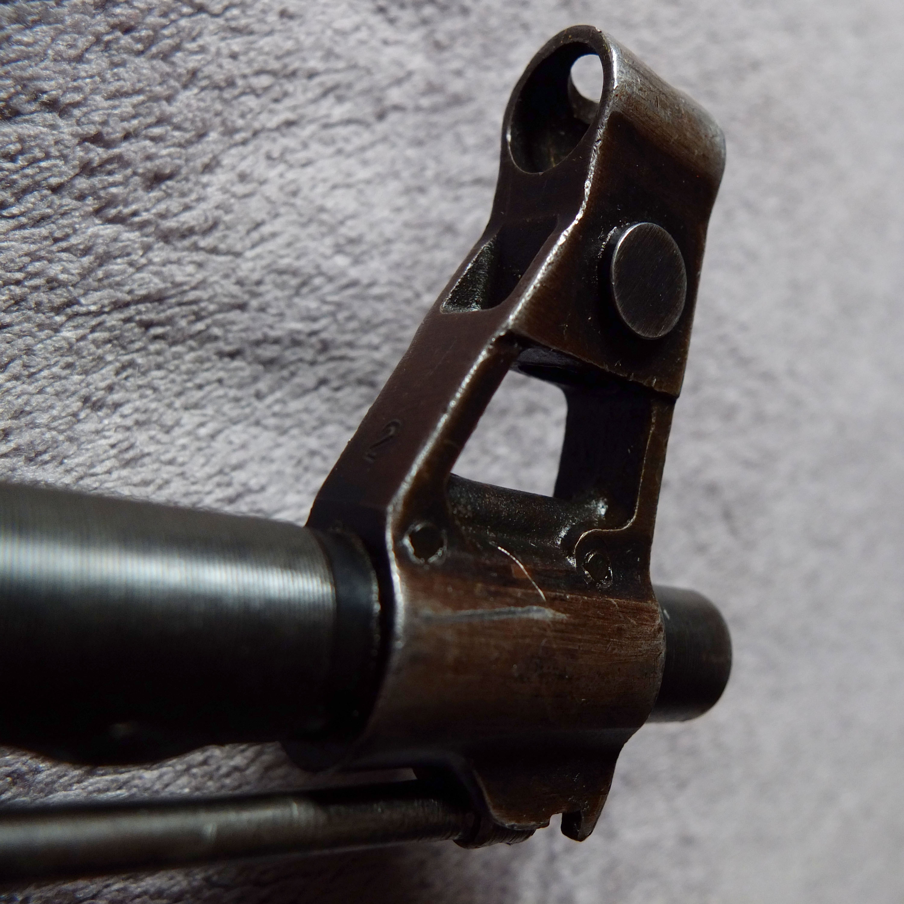 Figure 4 — The fully enclosed front sight hood on a Chinese Type 56-1. Other national patterns leave the top of the hood open; this closed ring is the single most reliable Chinese identifier on the platform.