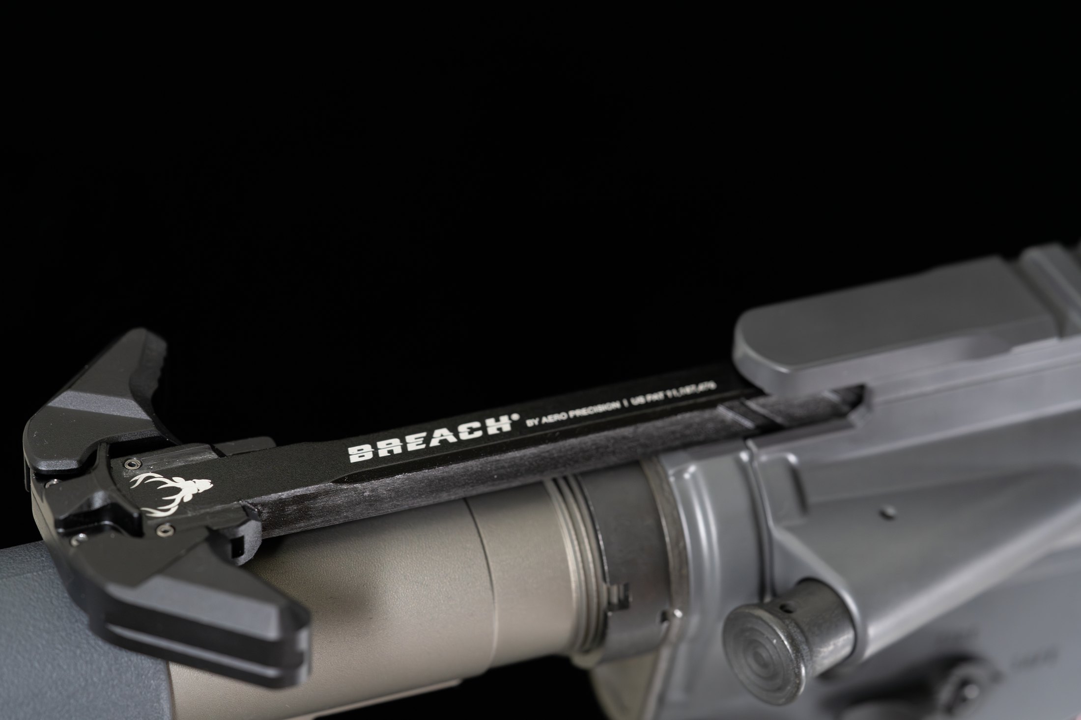 Figure 5 — A charging handle in an upper receiver. It is one of the few parts on the rifle where an aftermarket replacement addresses a real ergonomic shortcoming rather than a cosmetic one.