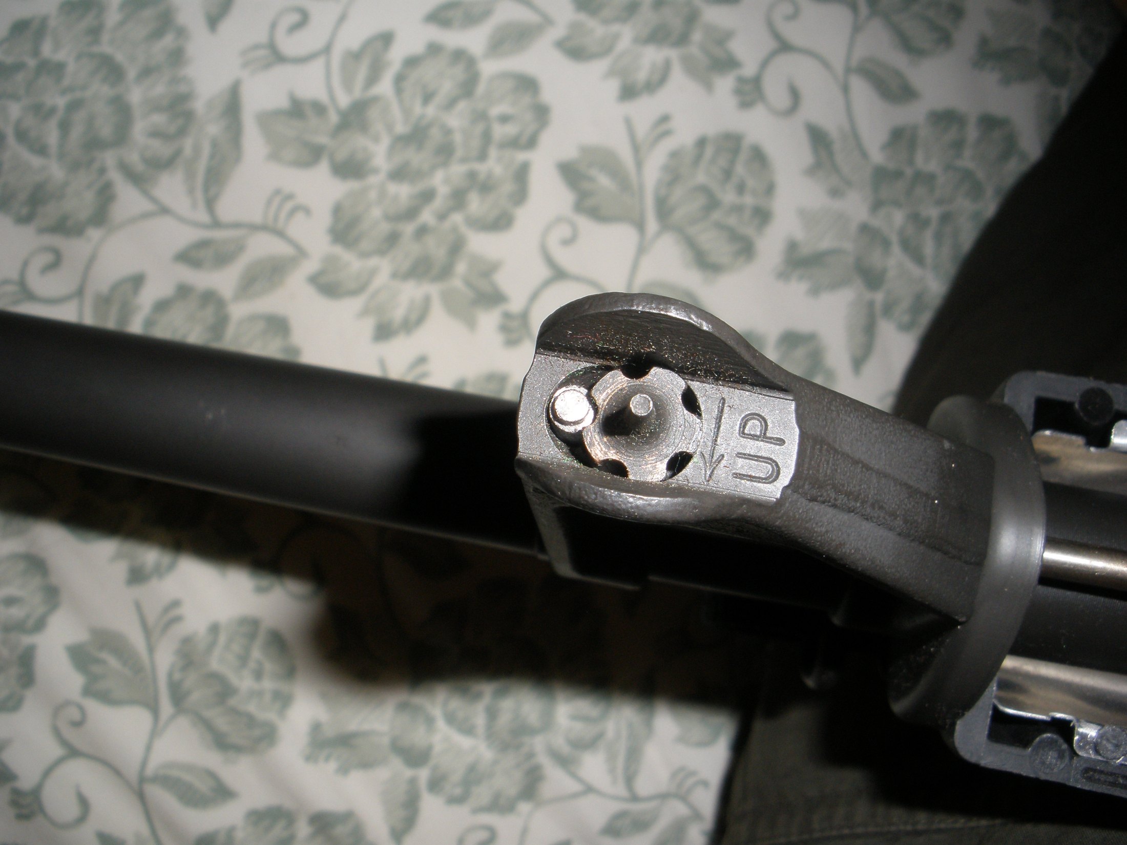 Figure 5 — The front sight post of an M16-pattern rifle, with the elevation detent and the UP marking. Fixed front sights are simple and durable and they sit in the sight picture of every optic mounted behind…