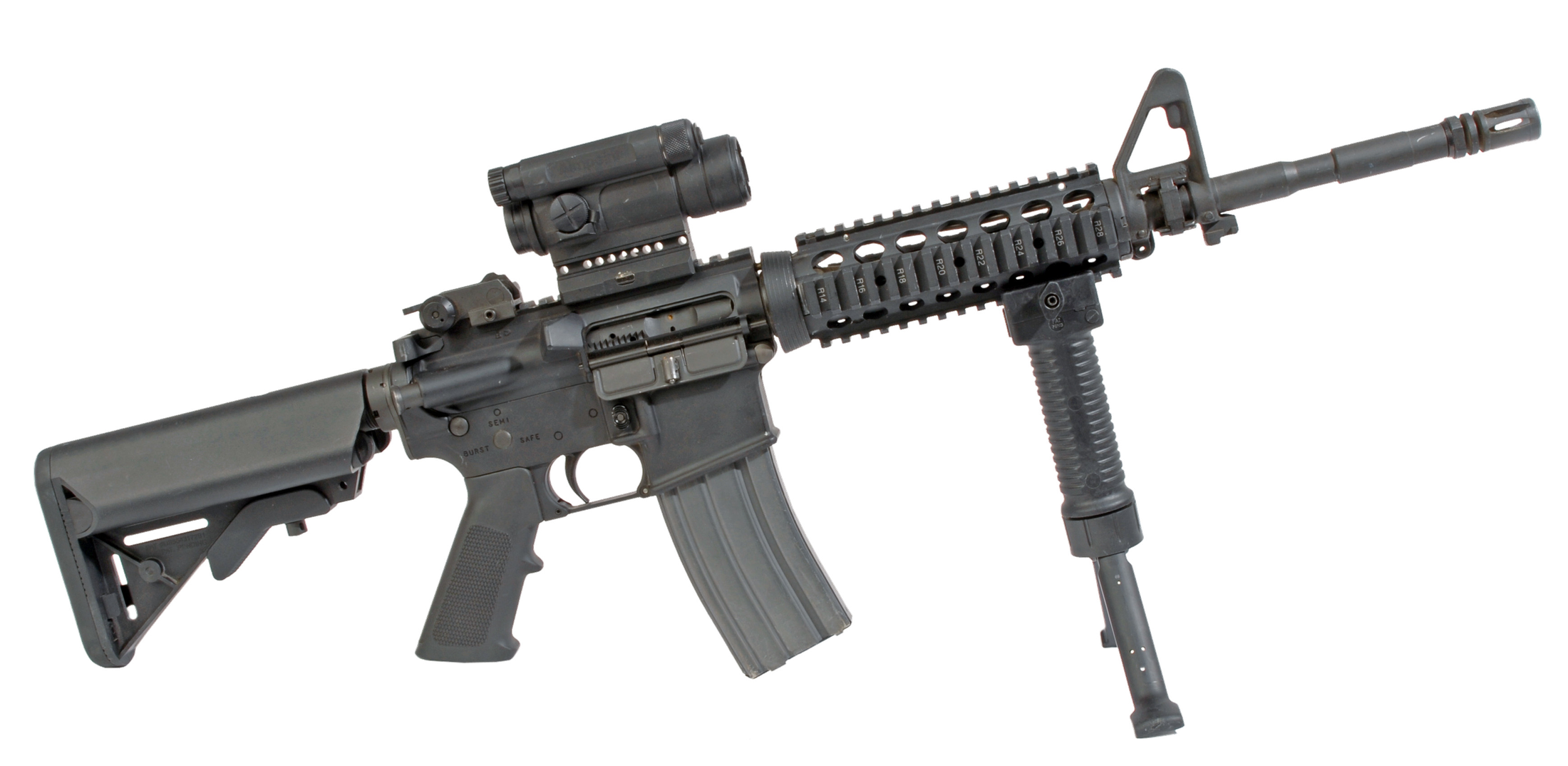 Figure 3 — An M4 carbine with an M68 close combat optic and a vertical foregrip — the service configuration that established the red dot as the default carbine sight.