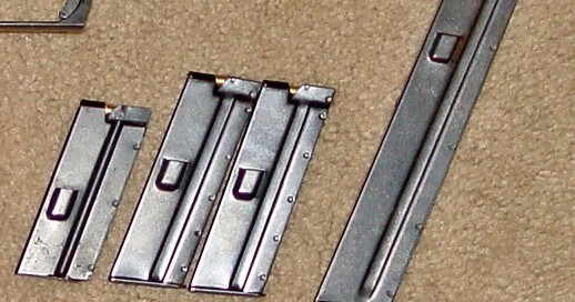 Figure 4 — ArmaLite AR-7 magazines: three standard 8-round magazines and, at right, a longer magazine. The feed lips and ramp at the open end of each magazine are what guide the cartridge into the chamber; th…