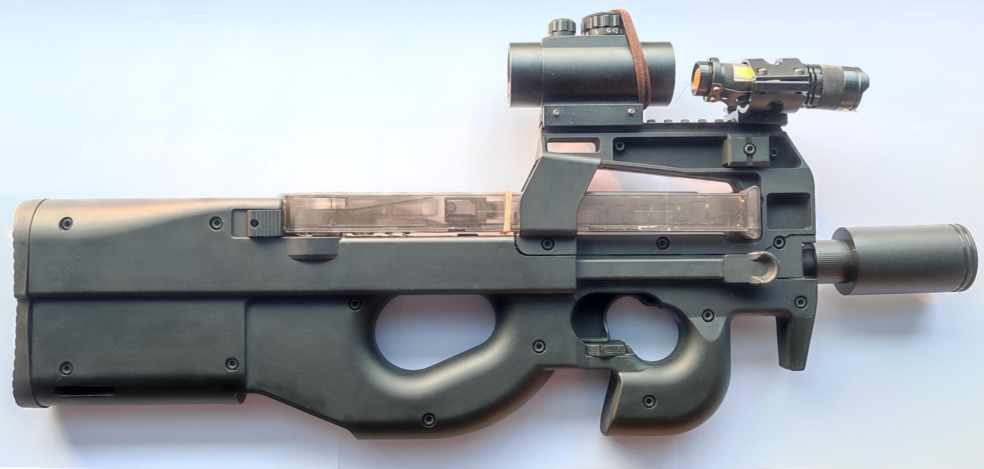Figure 4 — A P90 TR fitted out: red dot, magnifier, weapon light and suppressor. The rail generation is what makes this possible; nothing of the sort can be bolted to a Standard.