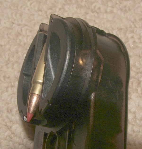 Figure 9 — The magazine seated on the weapon, showing how little the fifty rounds add to the silhouette. The flat top-mounted magazine is the reason the package is as small as it is.