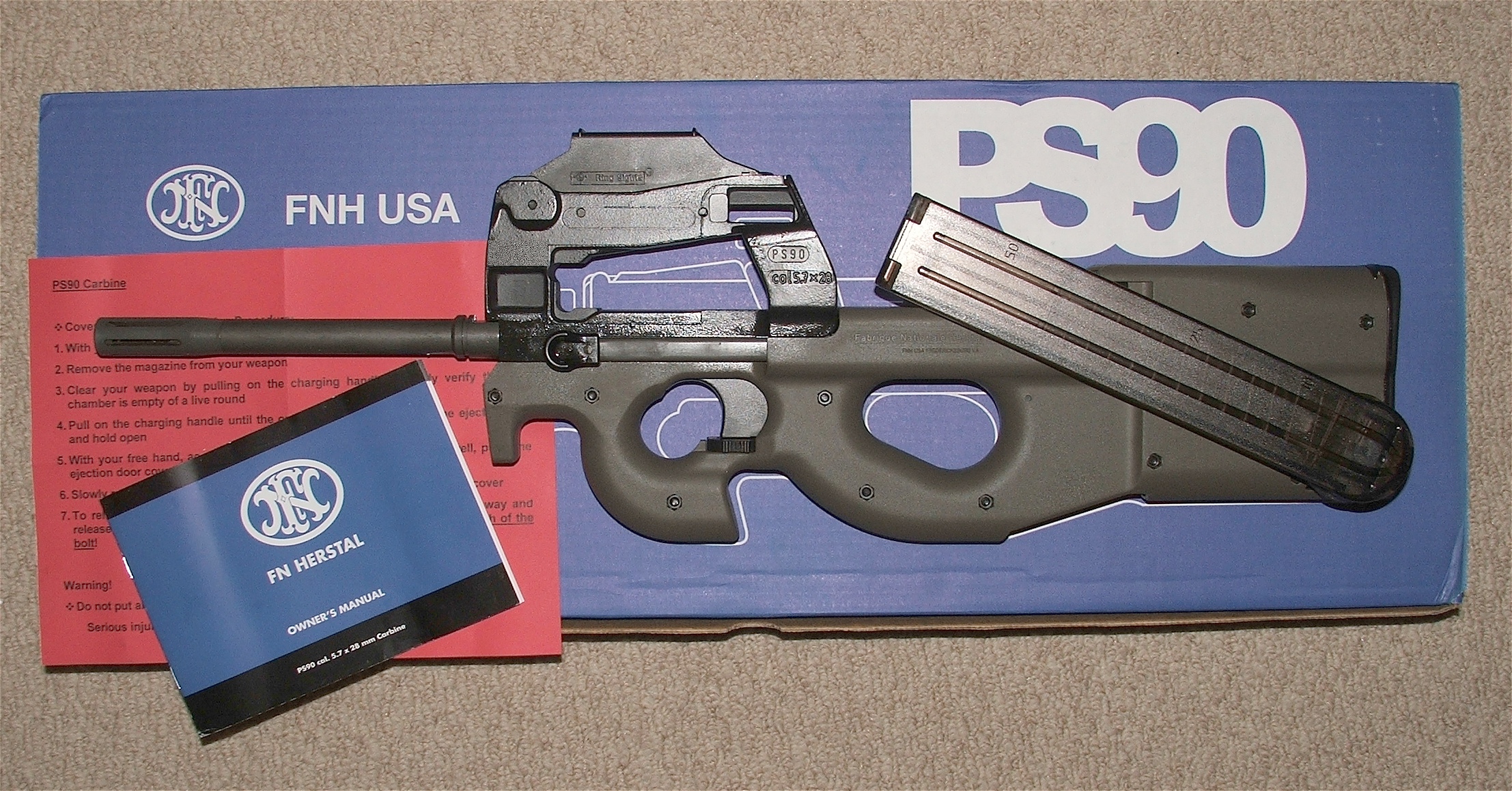 Figure 8 — A PS90 with its original box and documentation. Original packaging and the manual are worth having, and an owner who kept them is usually an owner who kept the weapon clean.