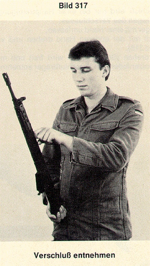 Figure 4 — Removing the bolt: with the stock and grip off, the cocking lever draws the bolt group rearward out of the receiver.