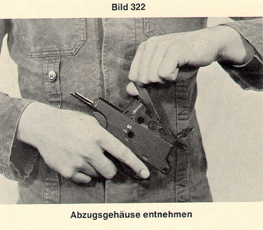 Figure 12 — Lifting out the G3 trigger housing with the safety lever drawn: the regulation's photograph of the step the PSG1 booklet describes in words.