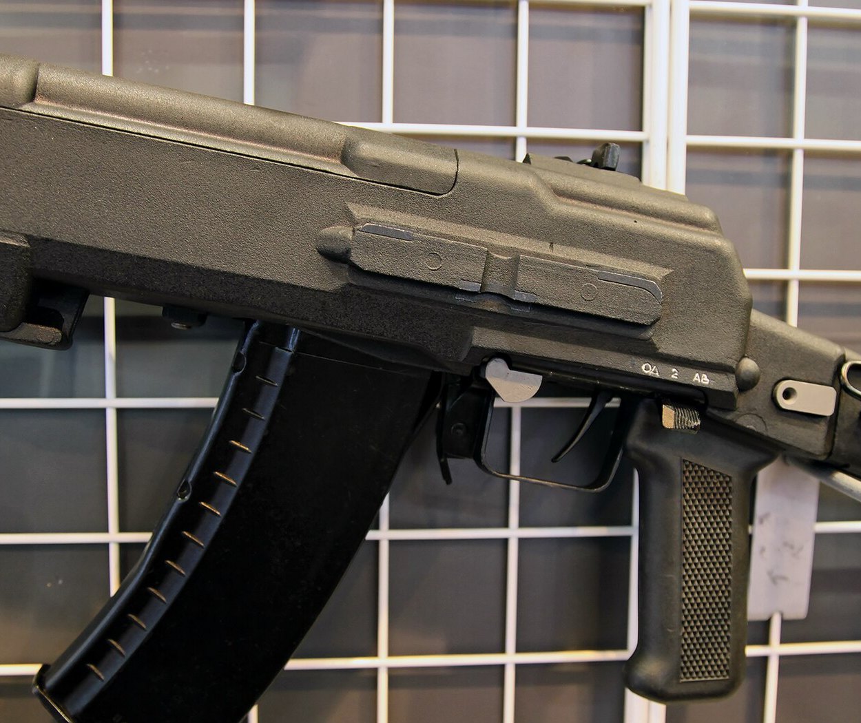Figure 9 — Close-up of an AN-94's left side at an exhibition: the polymer housing over the moving barrel-and-receiver unit, the small fire selector above the pistol grip with its three positions marked ОД (si…