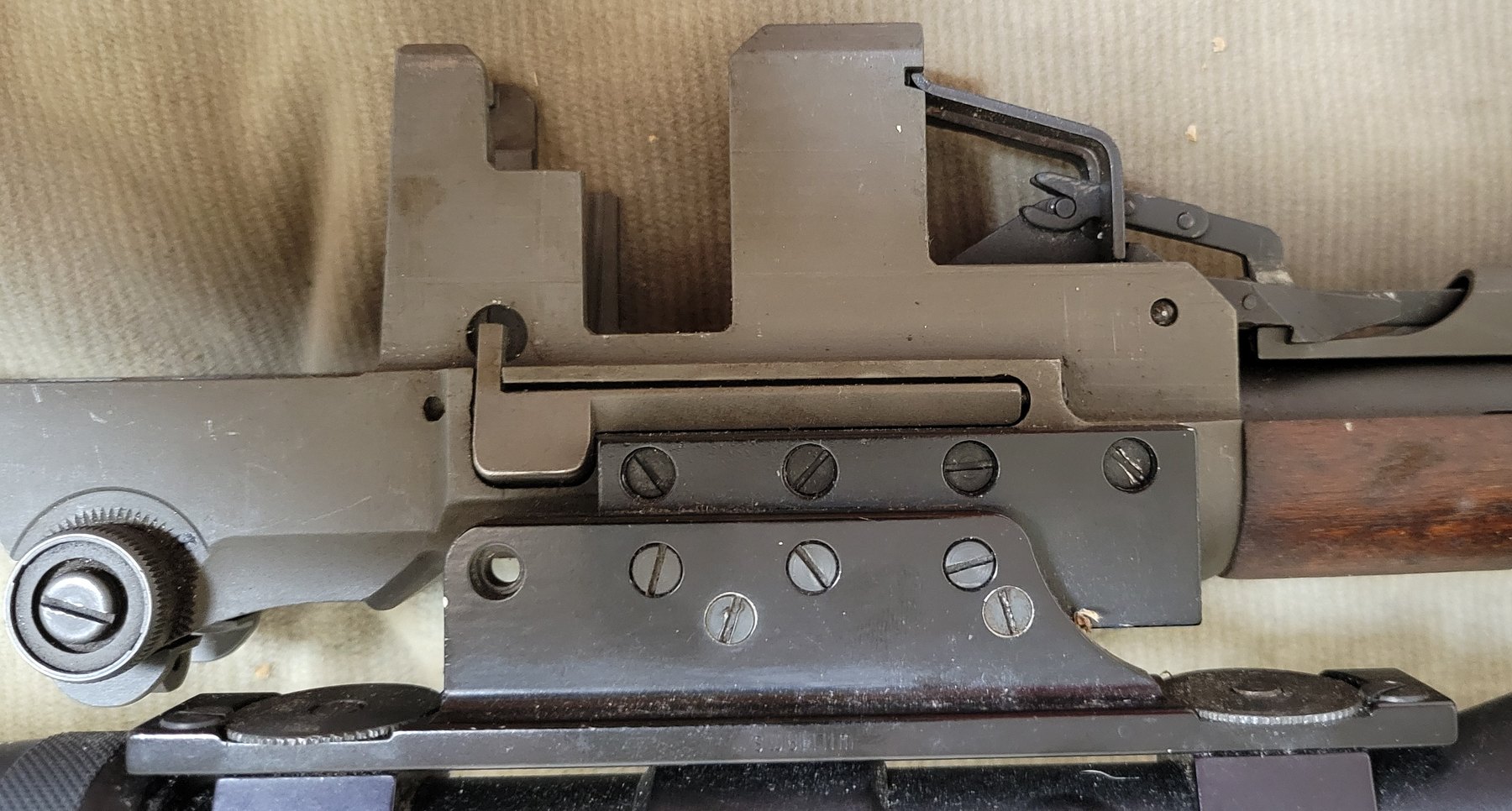 Figure 17 — The mount on the left of the receiver: a bar with four slotted screws against the receiver wall, and an adjustable plate carrying the scope rail.