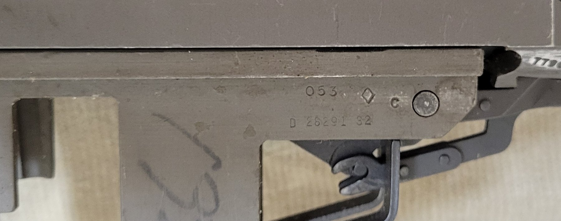 Figure 3 — The right front leg of the receiver, with the stock off. The upper line reads 053, a diamond, and C; the lower line reads D 28291 32. A previous owner wrote "32" on the leg in marker.