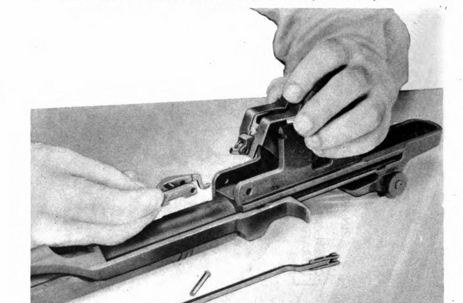 Figure 4 — Taking out the bullet guide and operating rod catch, from the ordnance manual. — U.S. War Department, TM 9-1275 (1942), Figure 25; public domain, via the Internet Archive.