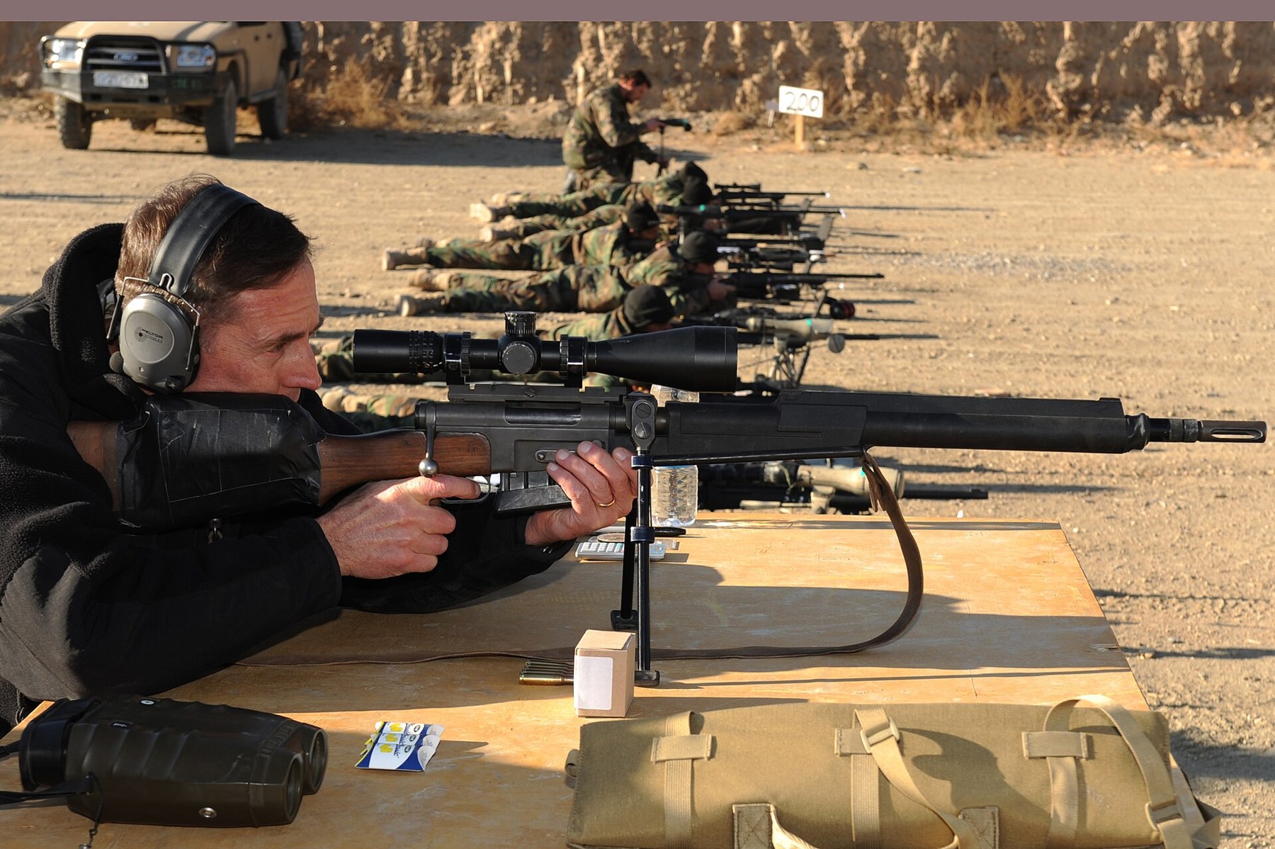 Figure 8 — General David Petraeus fires a rifle at Camp Morehead, Kabul, 16 December 2009. The rifle shows every external feature of an FR-F2: thermal sleeve, yoke-mounted bipod, straight bolt handle, brown p…