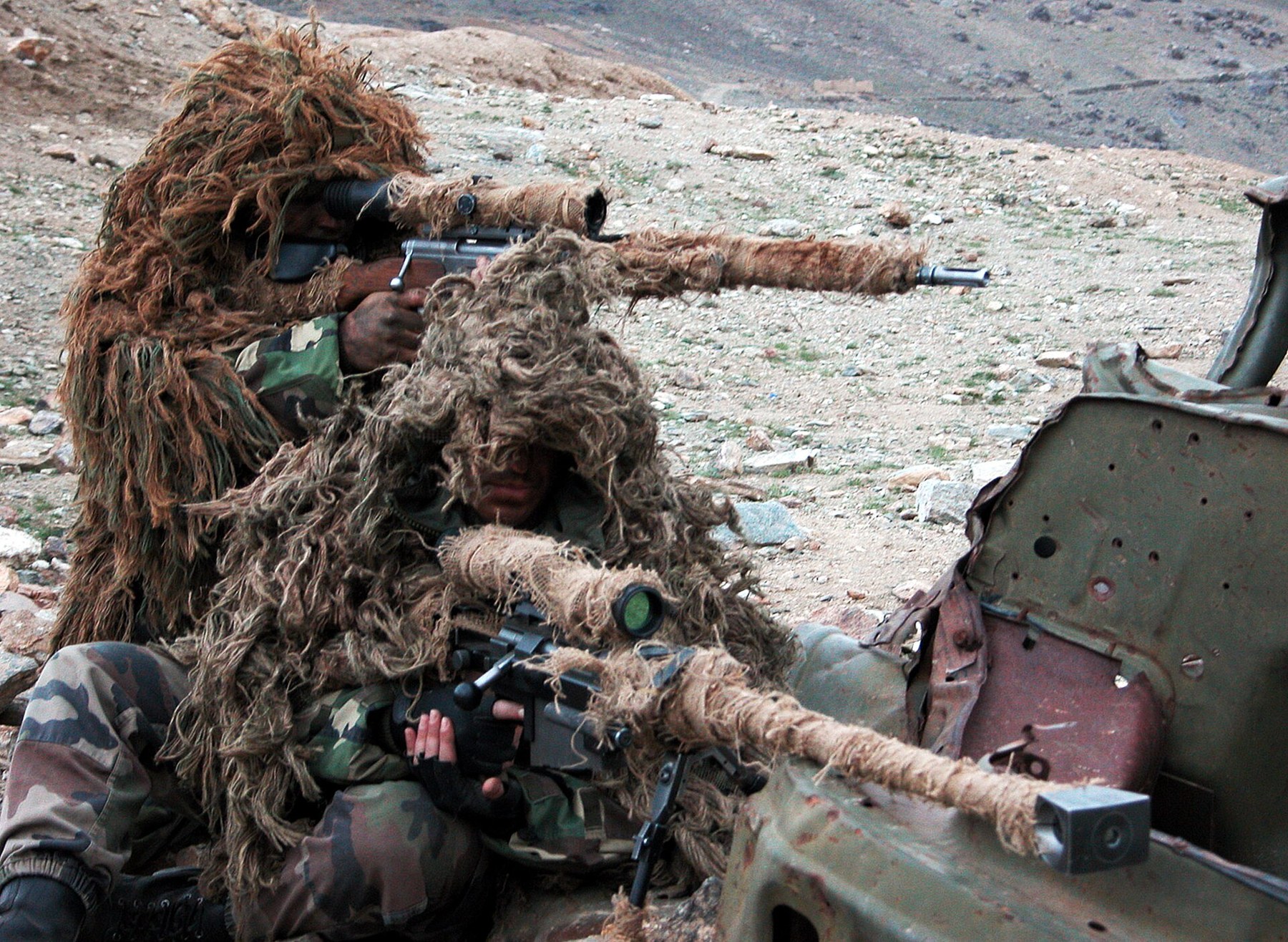 Figure 7 — Two 2e REI marksmen in ghillie suits in Afghanistan in 2005, one with a PGM Hécate 12.7 mm rifle and one with an FR-F2, both barrels wrapped in hessian. Photograph by davric, CC BY-SA 3.0, via Wiki…