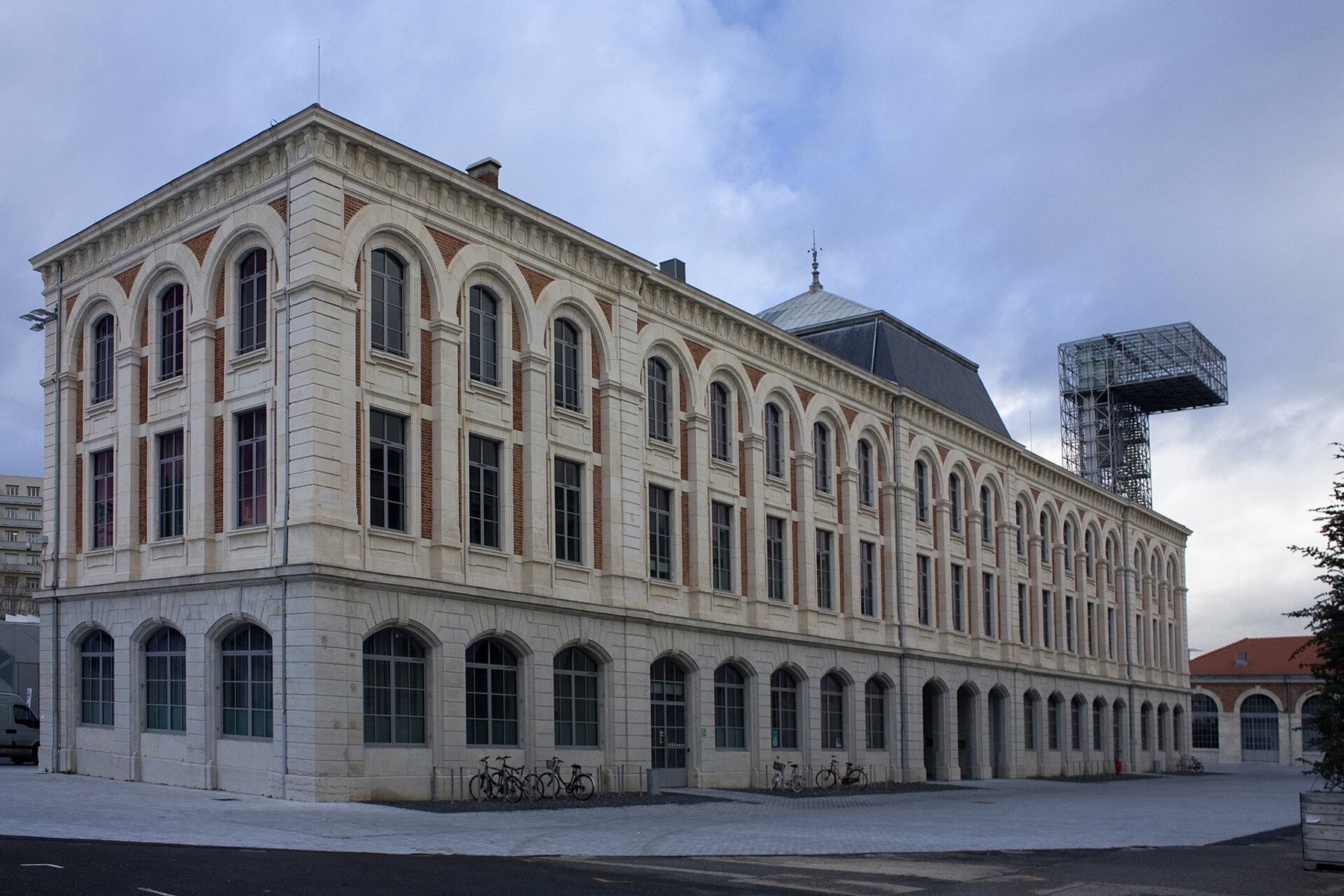 Figure 4 — The clock building of the former Manufacture d'Armes in 2011, which housed the factory's offices. The steel tower behind belongs to the Cité du design. Photograph by Daniel Villafruela, CC BY-SA 3.…