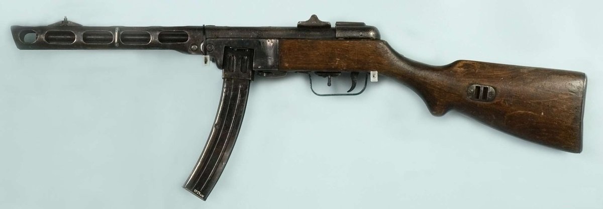 Figure 8 — A PPSh-41 fitted with the 35-round box magazine rather than the drum. The box was the later and more reliable answer, and it narrows the capacity gap with the MP 40's 32 rounds to almost nothing — …
