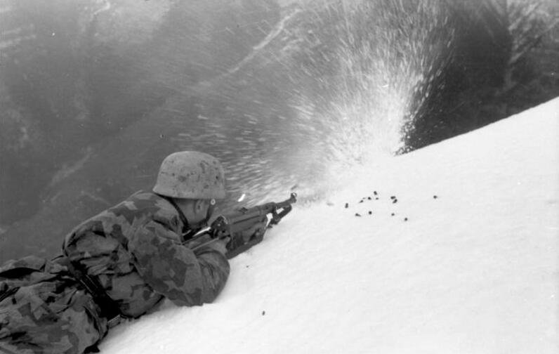 Figure 5 — A Fallschirmjäger firing an MP 40 from the prone in snow. Braced, shouldered, from a position — the way the weapon was actually used, and the way it is almost never shown.