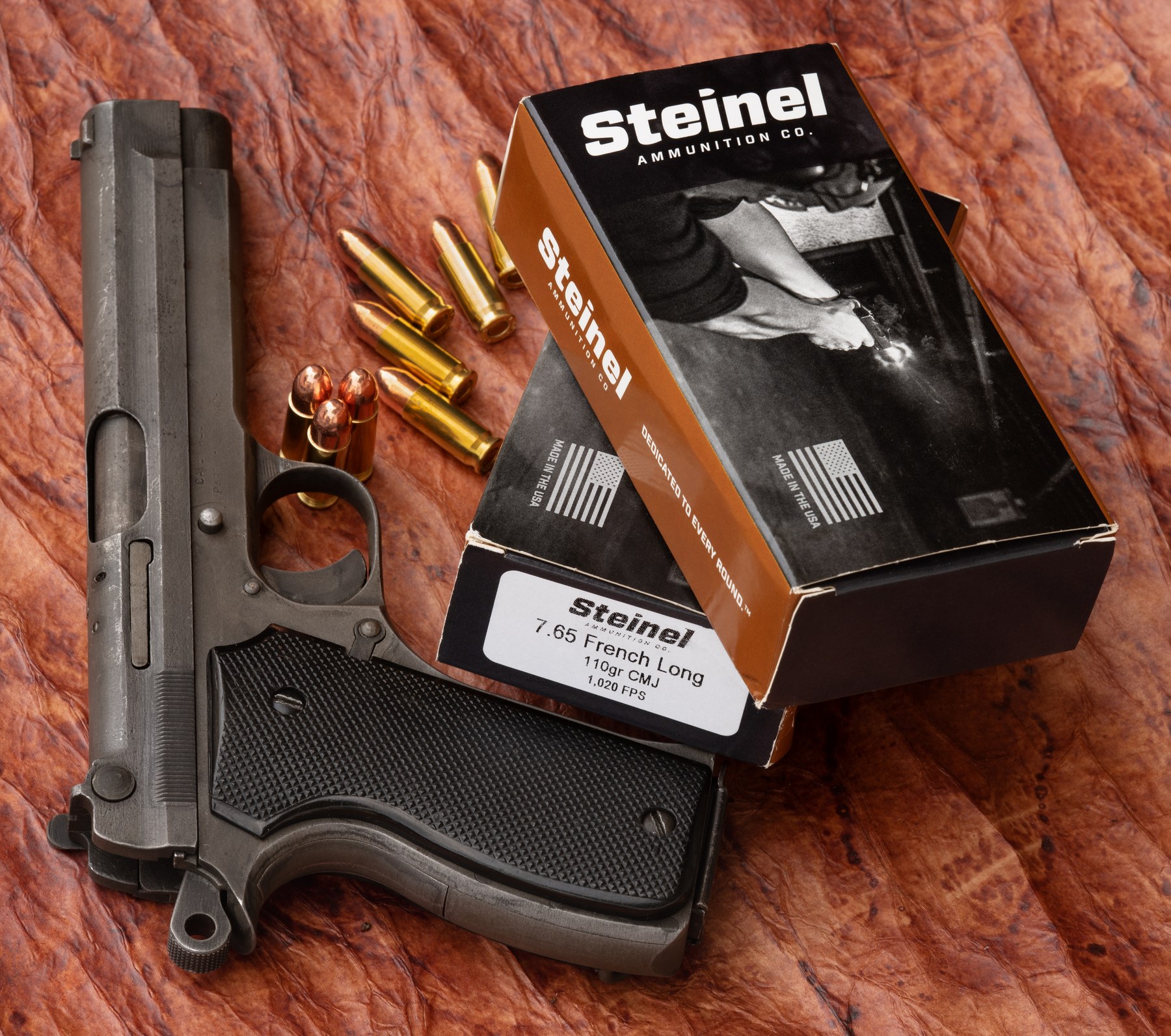 Figure 6 — Steinel's 7.65 French Long ammunition beside a pistol (the photograph's title does not name it). Oleg Volk, CC BY-SA 4.0, via Wikimedia Commons.